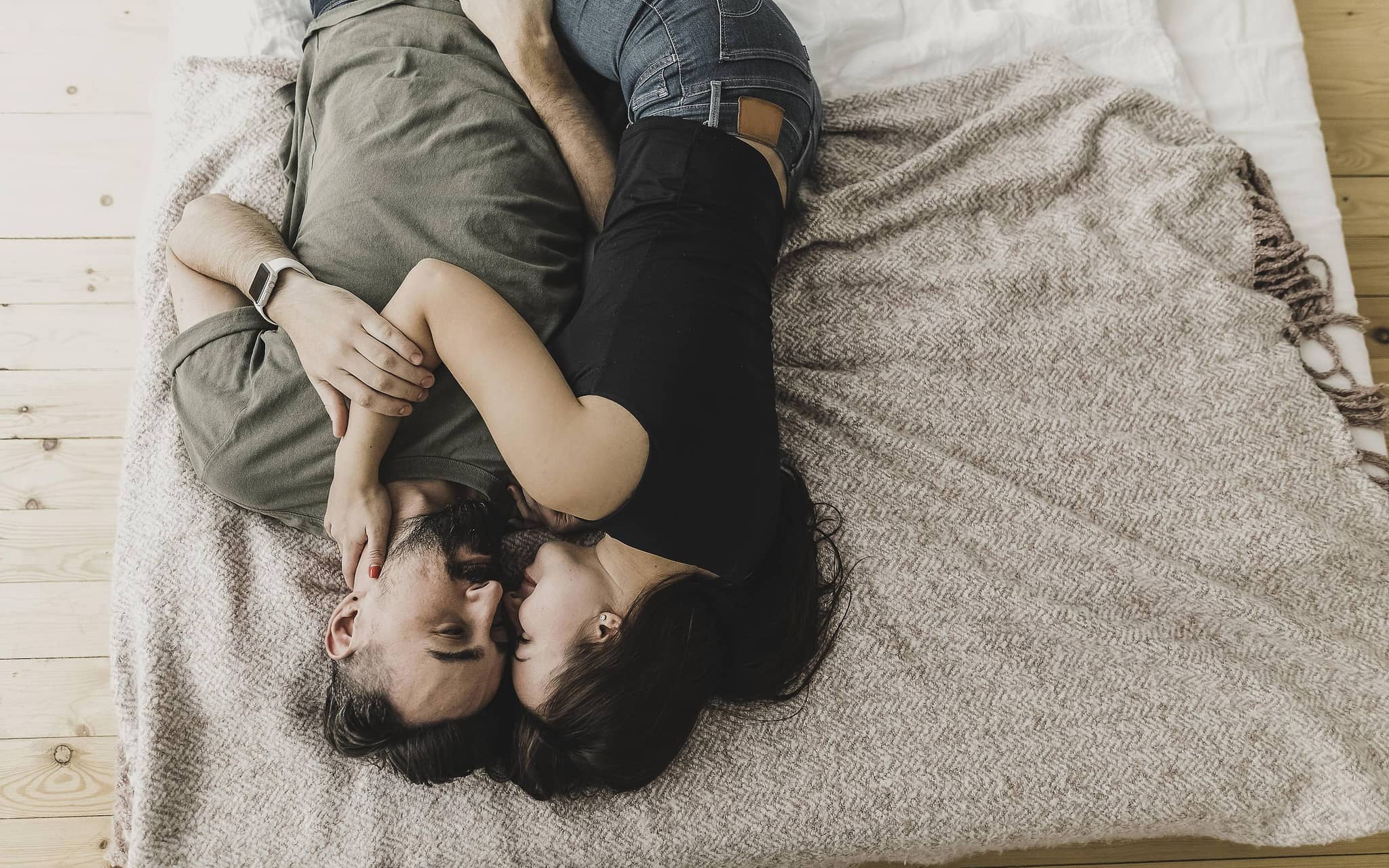 Mann und Frau liegen liebkosend im Bett.