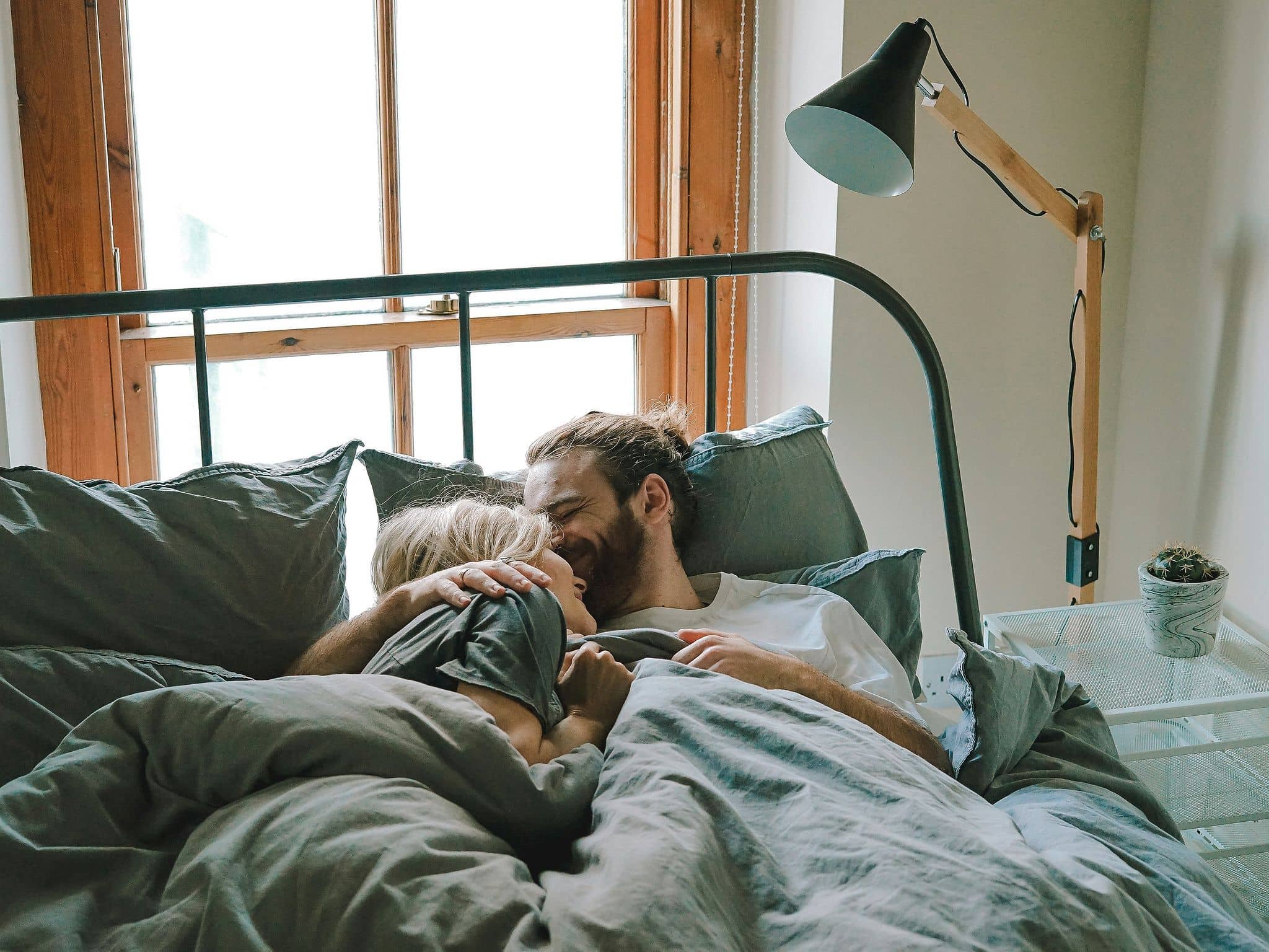 Frau und Mann liebkosen sich im Bett.