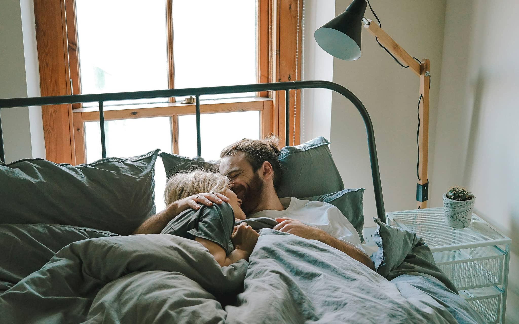 Frau und Mann liebkosen sich im Bett.