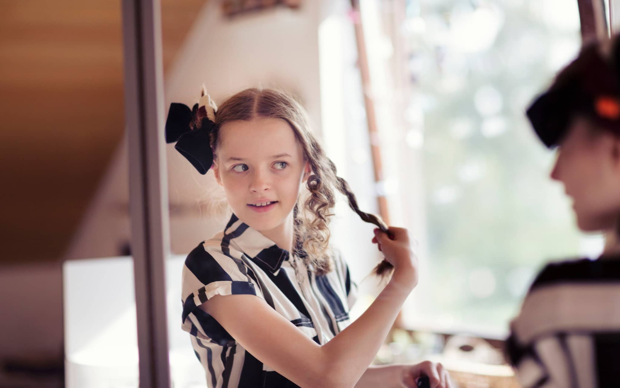 Symbolbild für bin ich schön: Ein junges Mädchen steht vorm Spiegel und sieht sich an