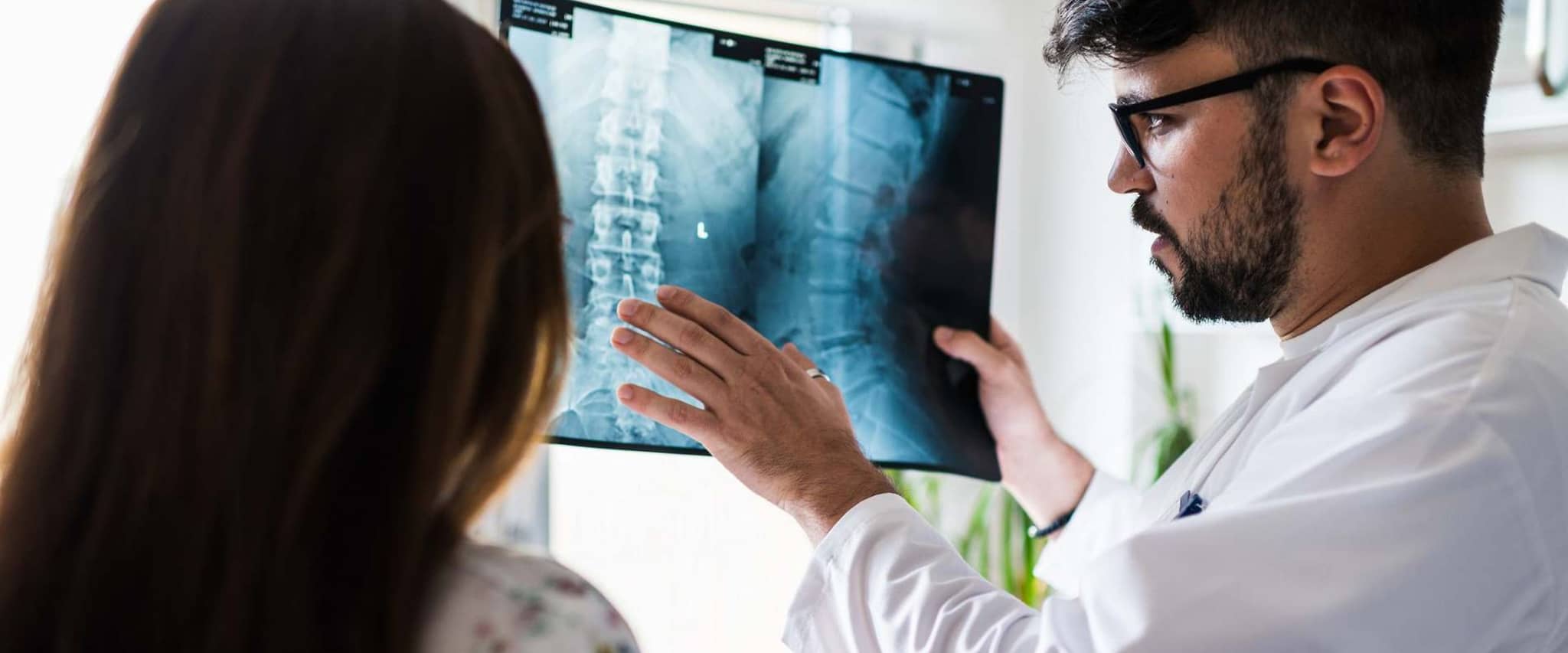 Bild: Arzt erklärt einer Patientin etwas zu ihrem Röntgenbild der Wirbelsäule.