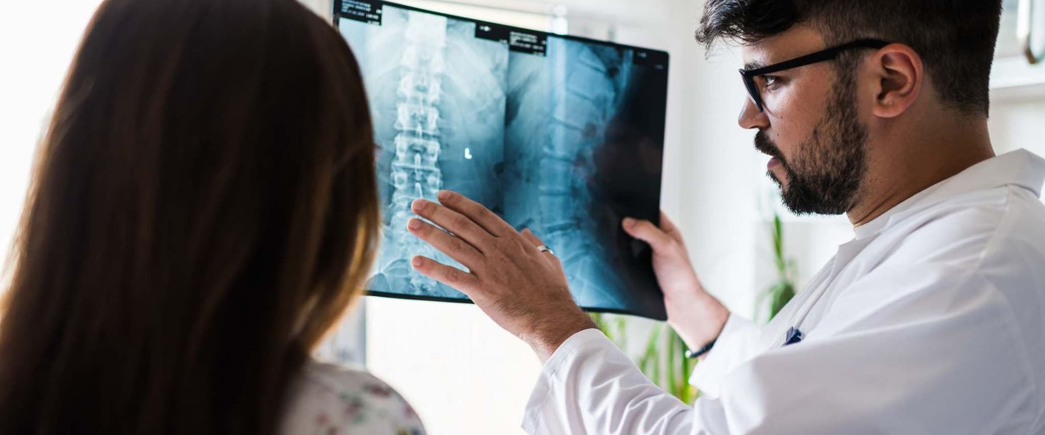 Bild: Arzt erklärt einer Patientin etwas zu ihrem Röntgenbild der Wirbelsäule.