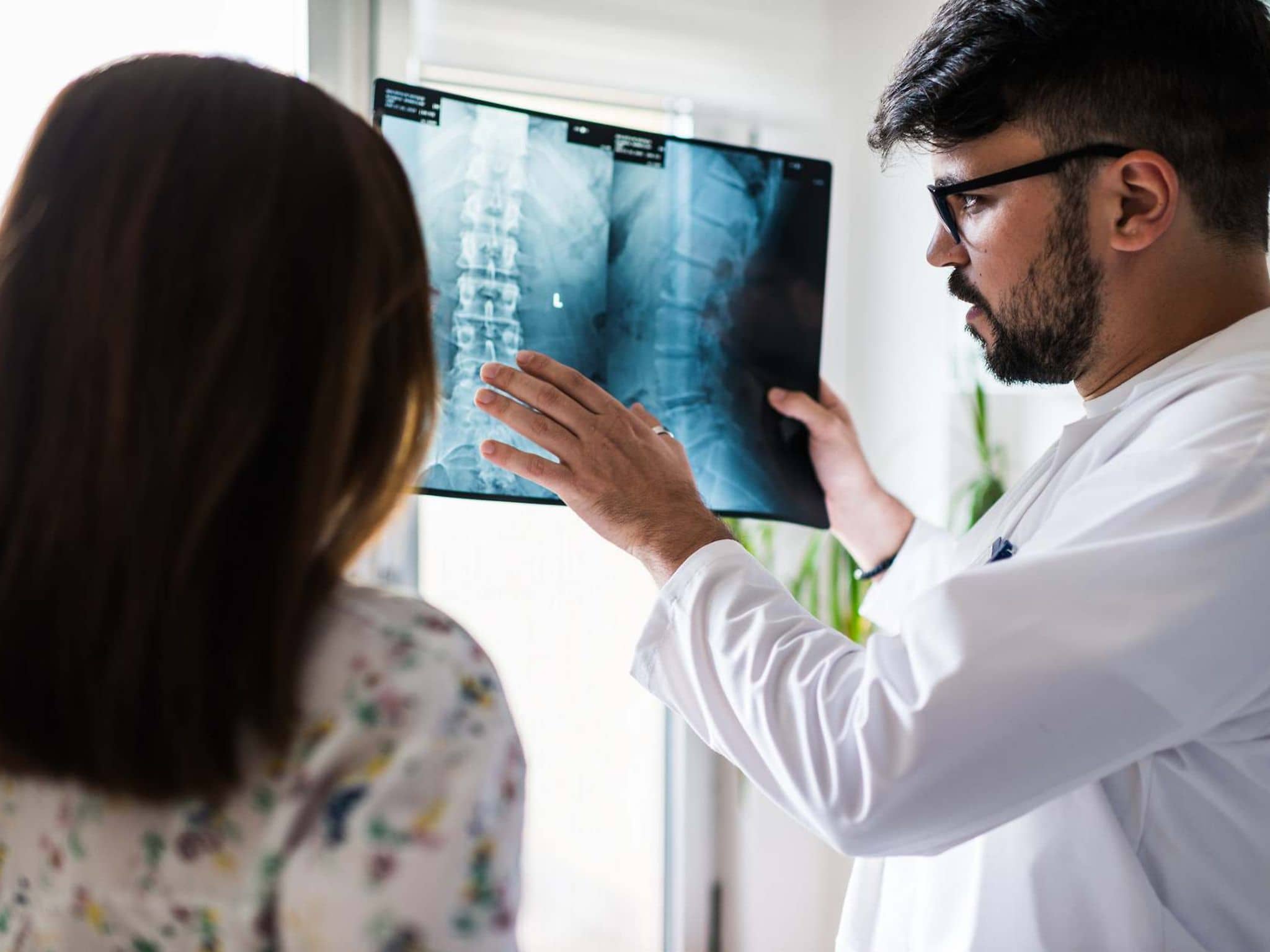 Bild: Arzt erklärt einer Patientin etwas zu ihrem Röntgenbild der Wirbelsäule.