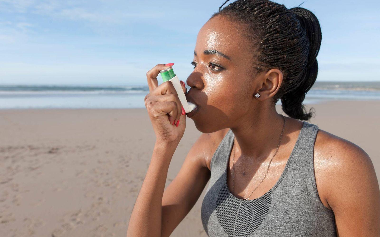 Asthma und Sport: Junge Frau nutzt Inhalator beim Laufen