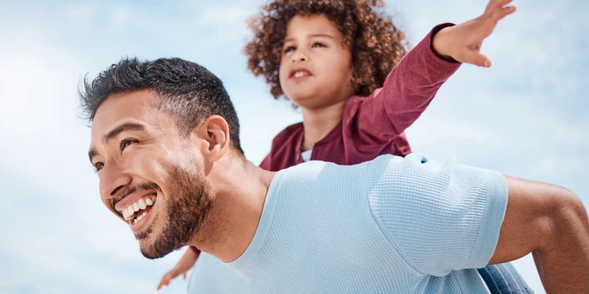 Osteopathie: Vater trägt seine Tochter auf dem Rücken.