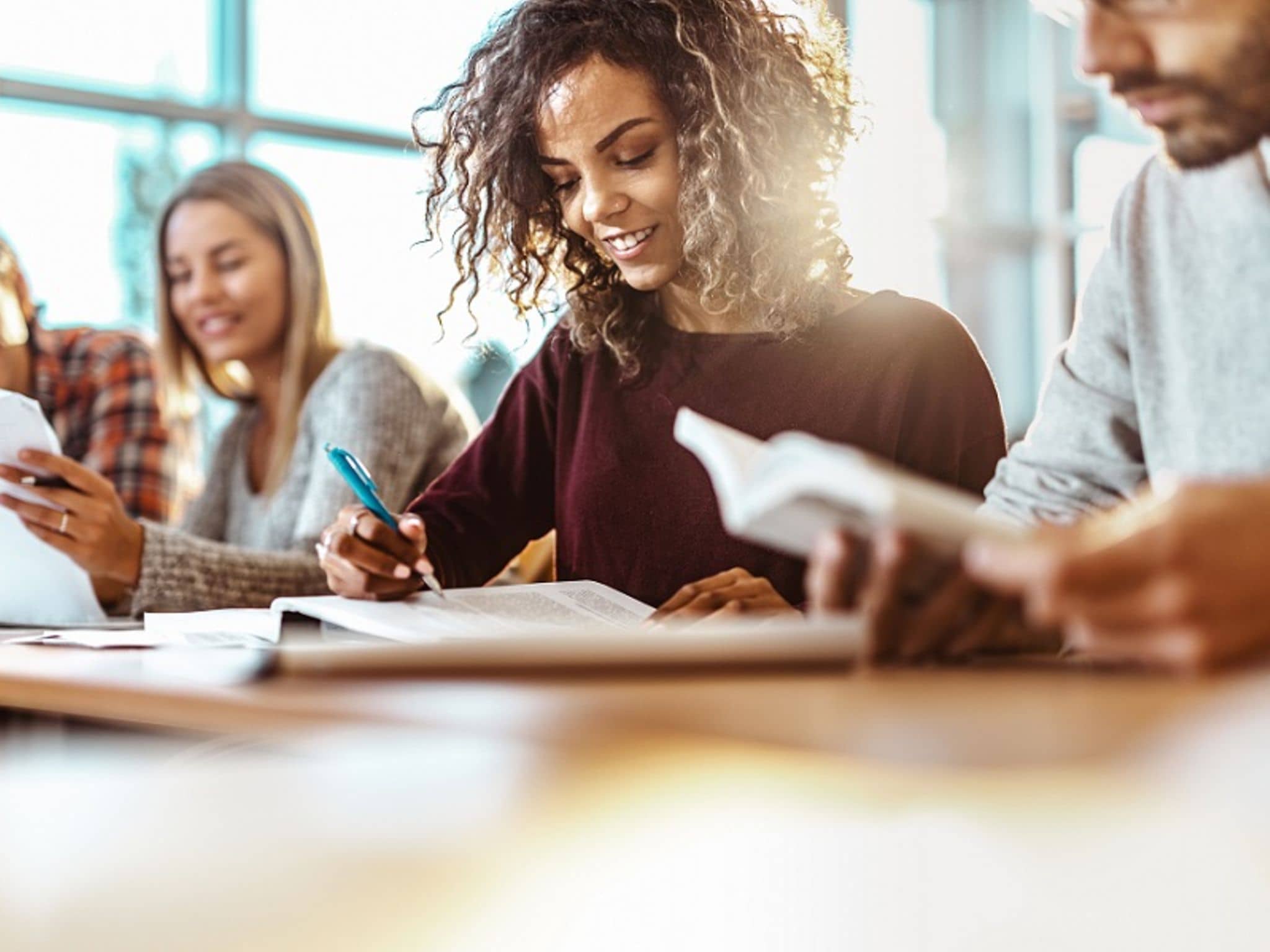 Junge Frau schreibt in ihr Heft.
