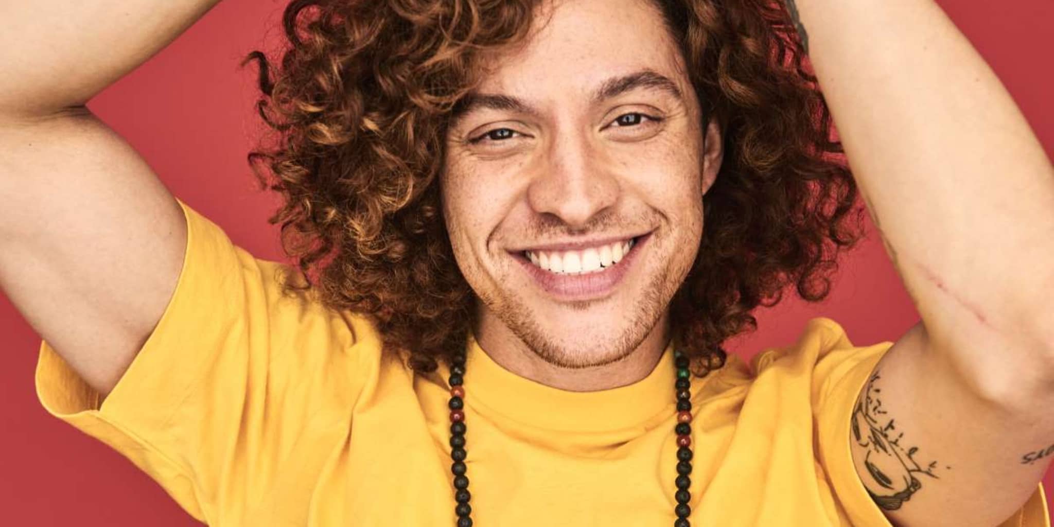 DAK Vorteilsrechner: Junger Mann grinst in die Kamera.