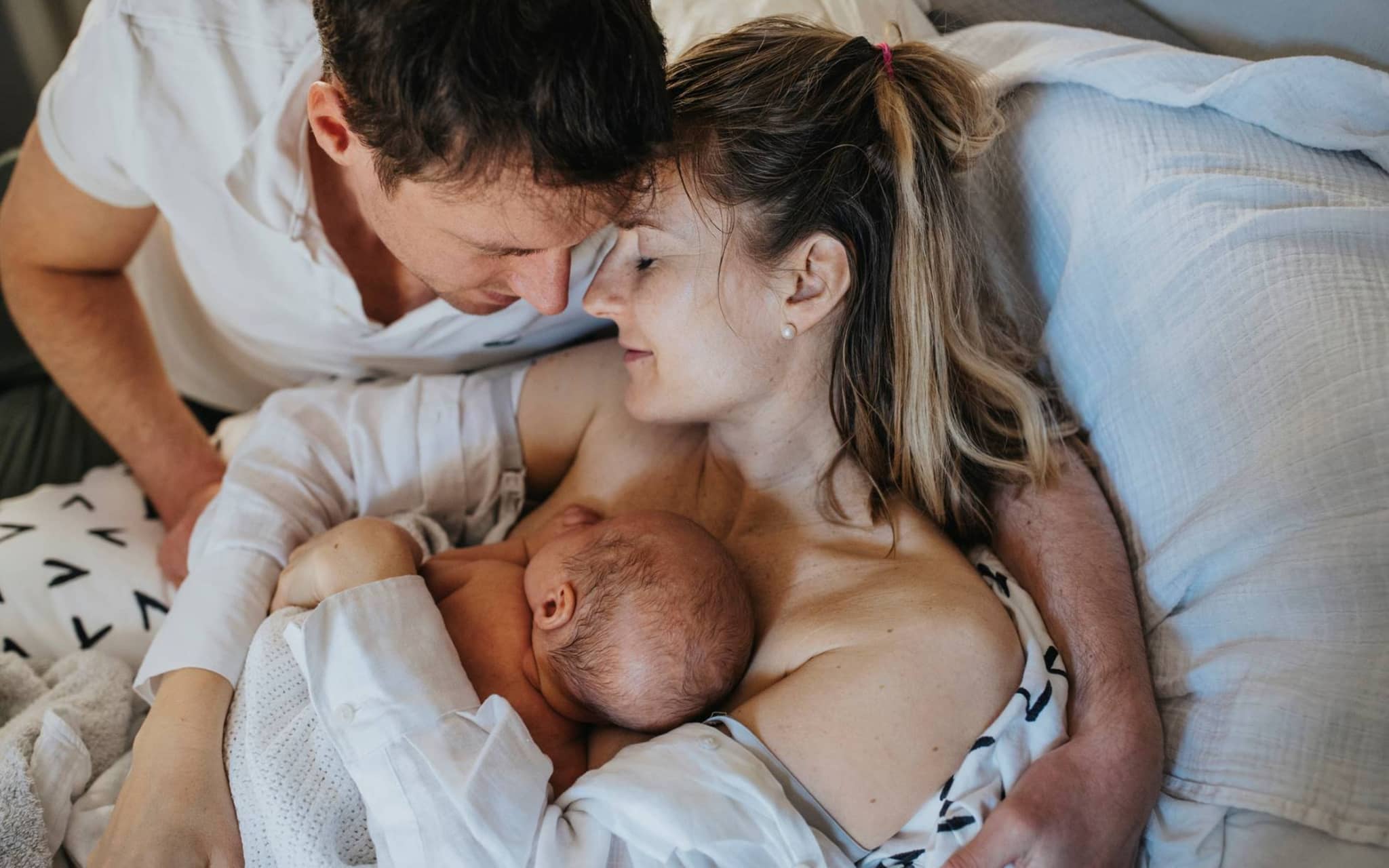 Symbolbild Ablauf einer Geburt: Eltern halten ihr Neugeborenes