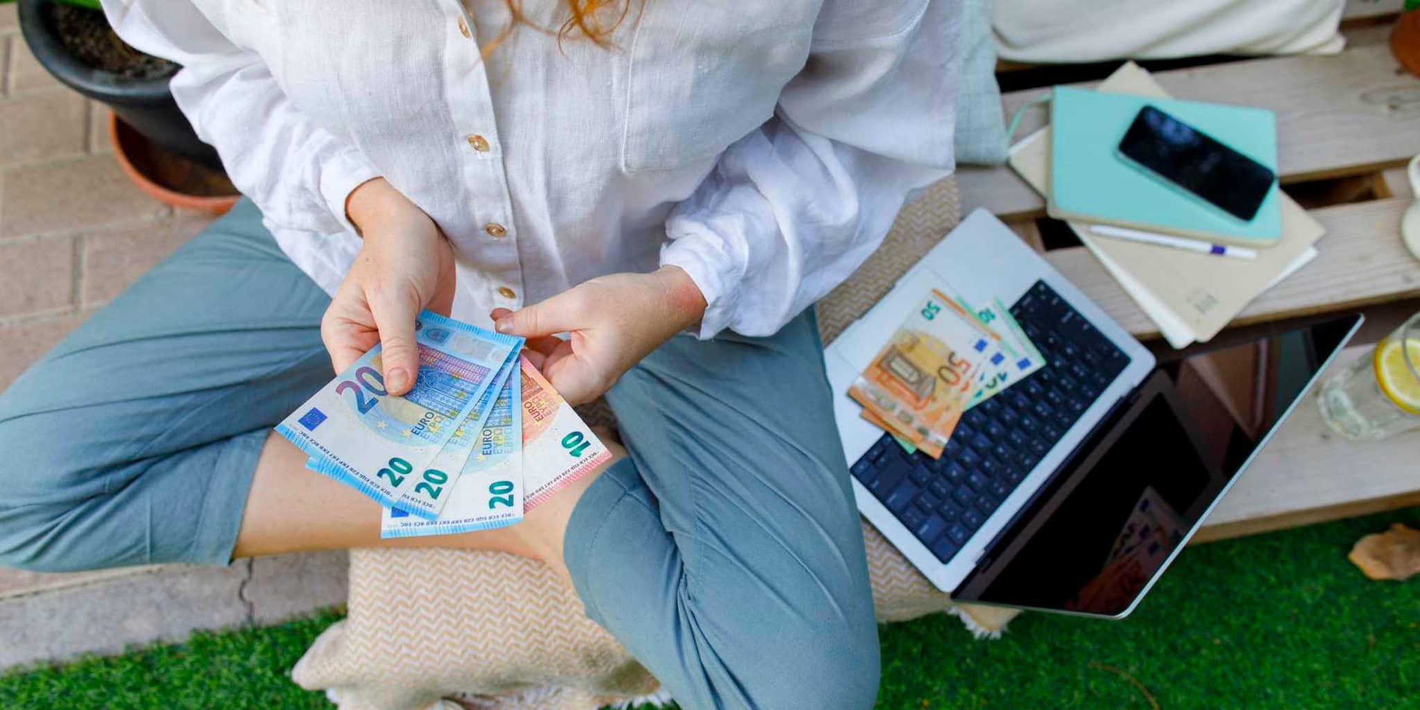 Bild: Frau hält Geldscheine in der Hand.