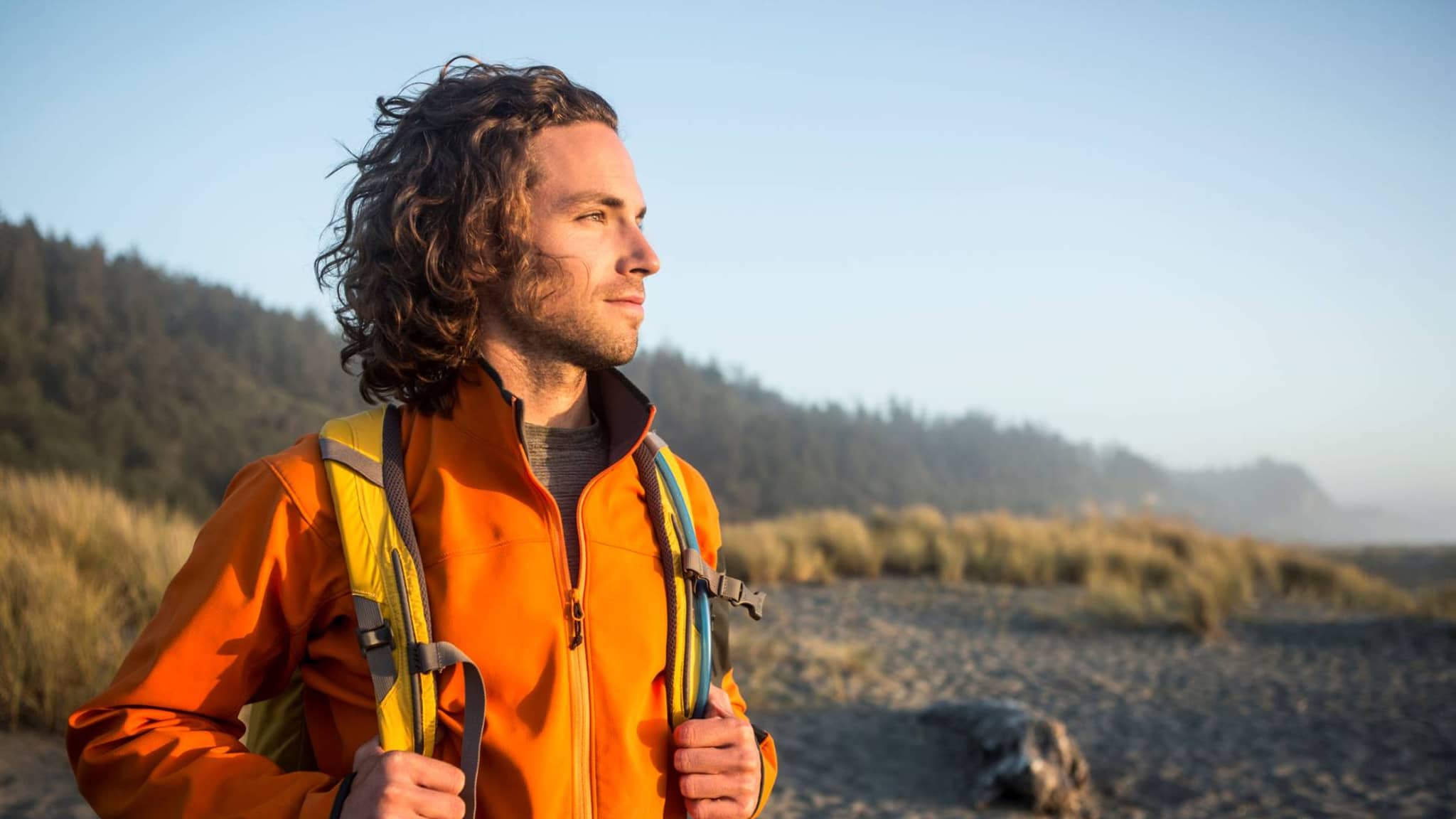 Junger Mann steht am Strand und lindert sein Asthma durch die Meeresluft.