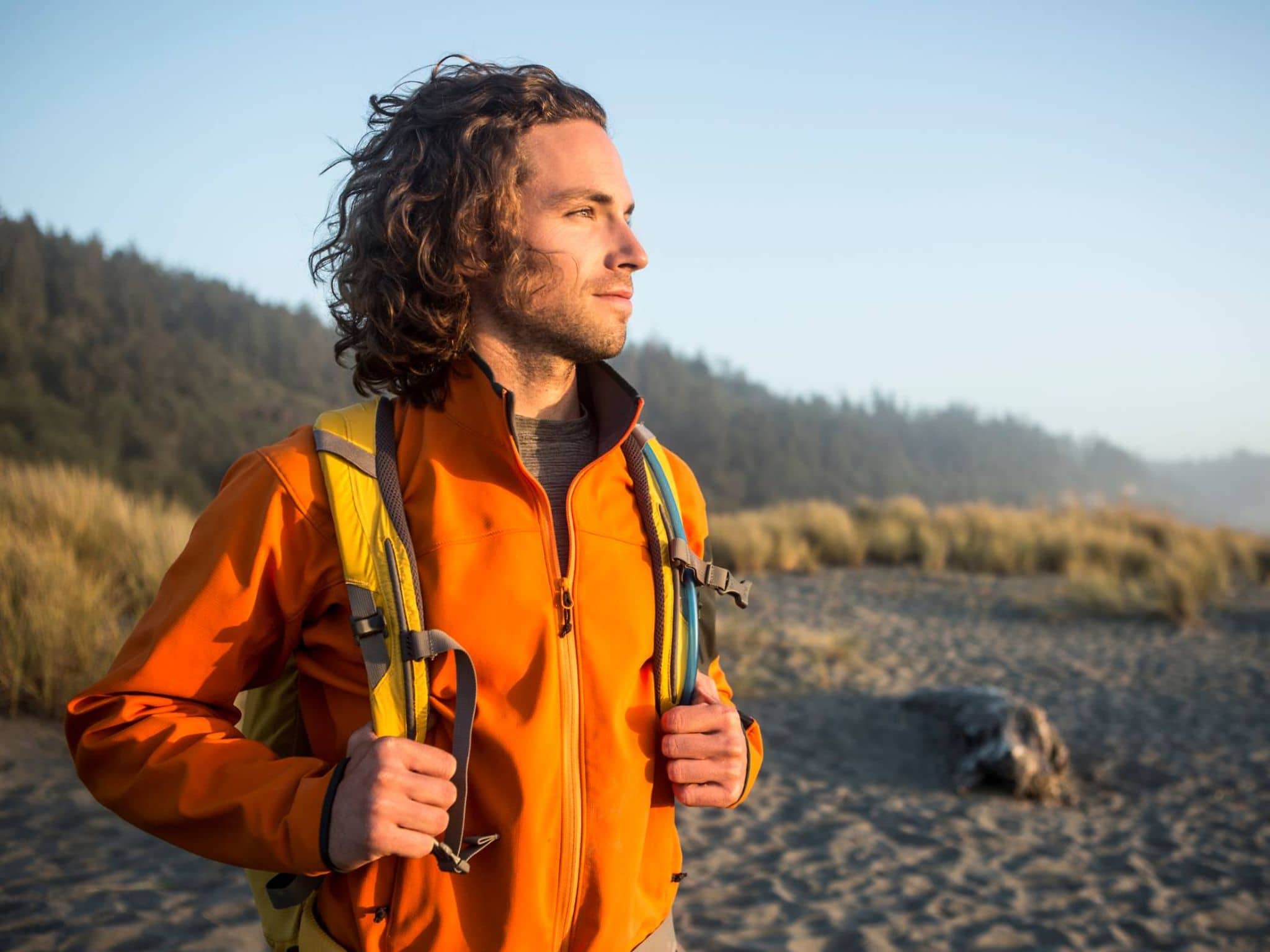 Junger Mann steht am Strand und lindert sein Asthma durch die Meeresluft.