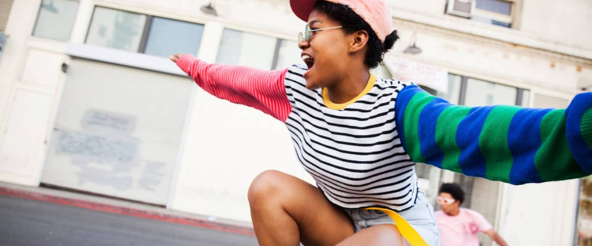 DAK bietet Vorteile in allen Lebenslagen: Junge Frau fährt fröhlich auf einem Skateboard
