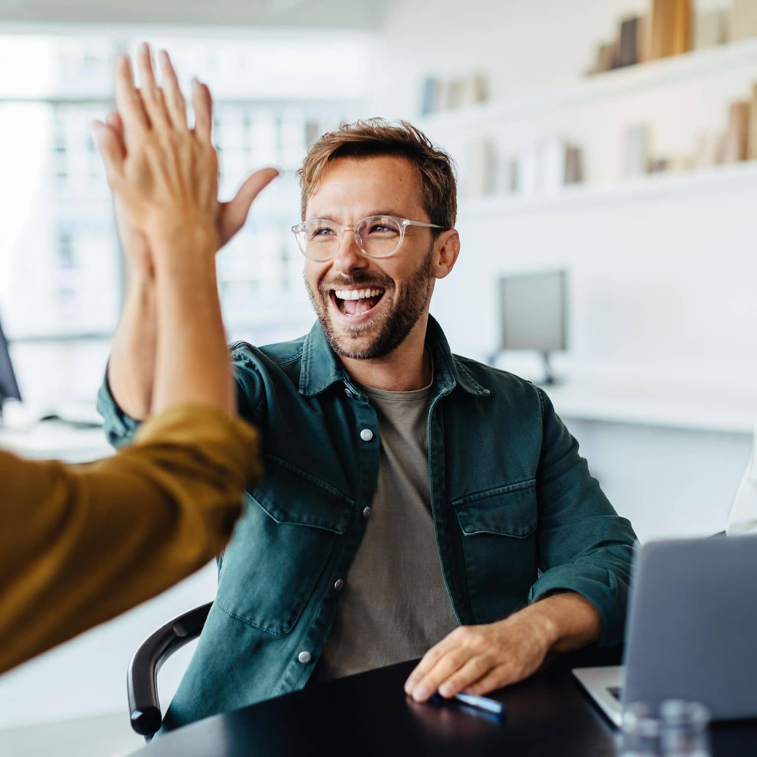 Bild: Kollege und Kollegin machen eine Faust und sehen zufrieden aus.