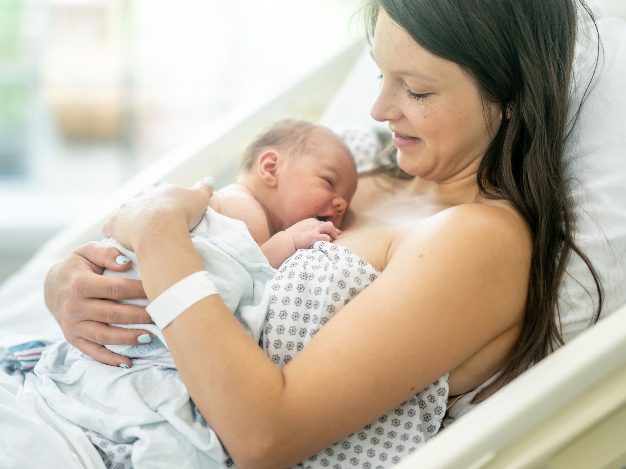 Symbolbild Neo-MILK-App Stillen: Säugling an der Brust der Mutter