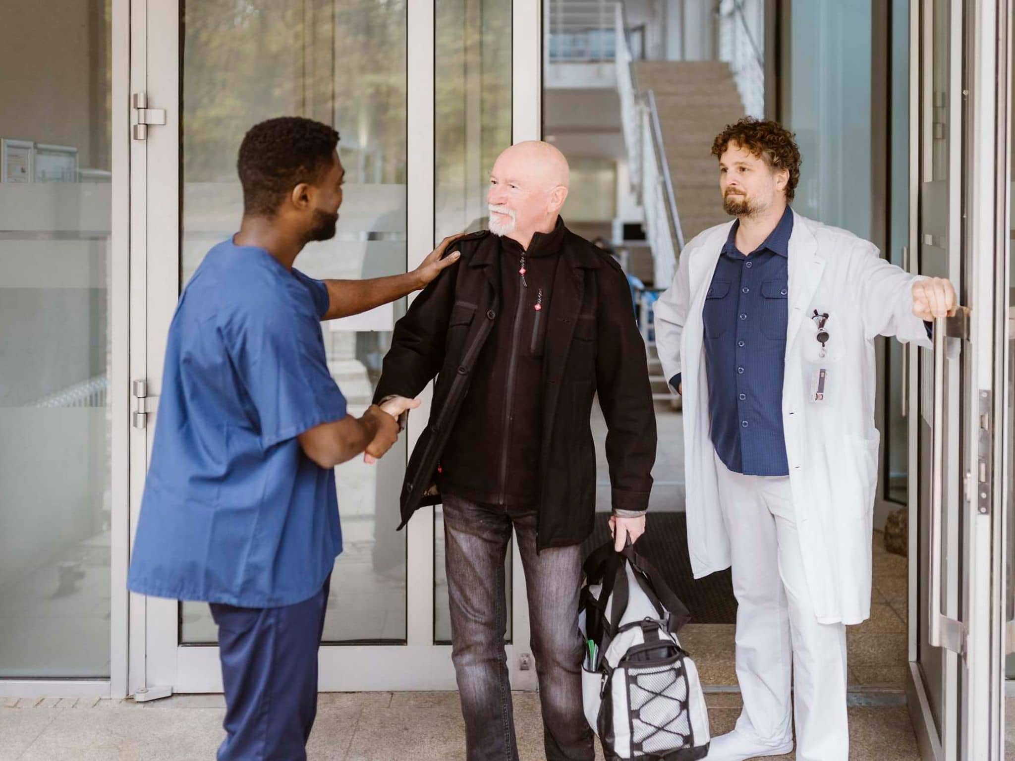 Bild: Pfleger verabschiedet sich von einem Krankenhauspatienten.