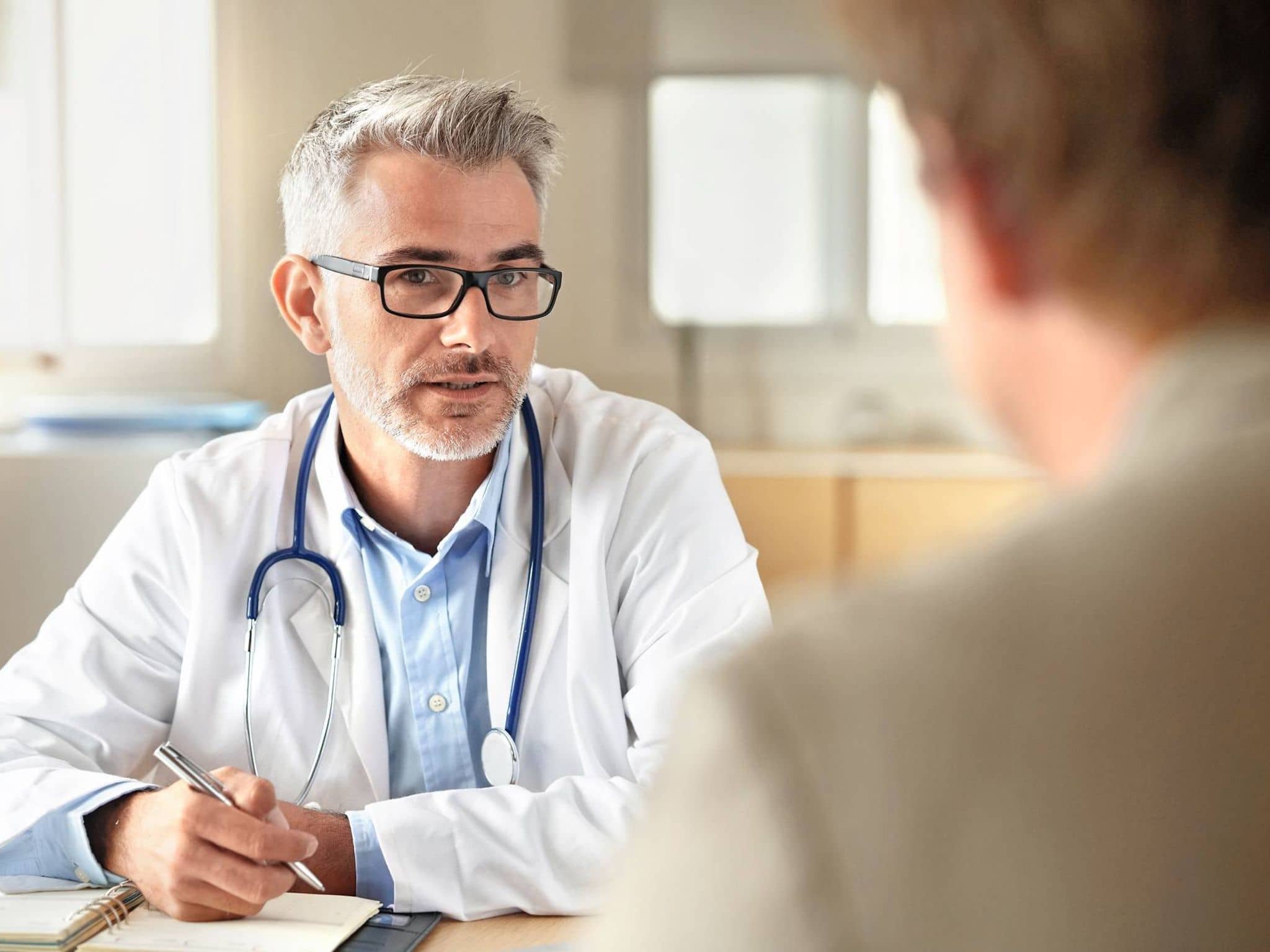 Bild: Arzt im Gespräch mit einem Patienten zu einem DMP Programm.