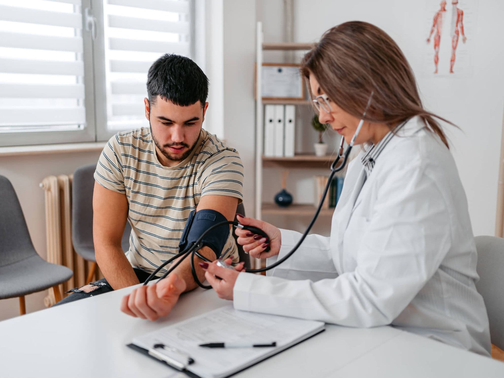 Bild: Ärztin misst Blutdruck bei einem Patienten