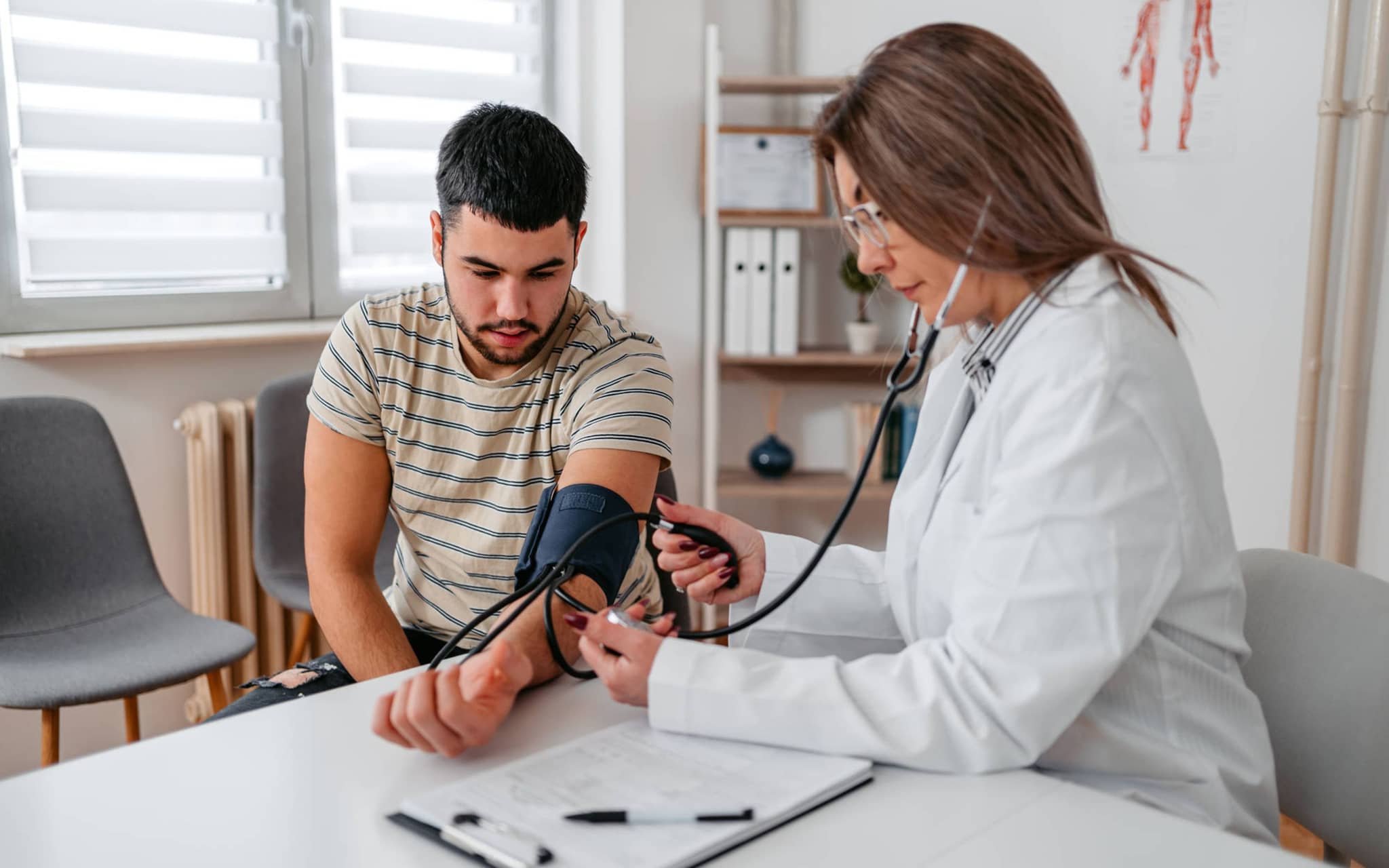 Bild: Ärztin misst Blutdruck bei einem Patienten