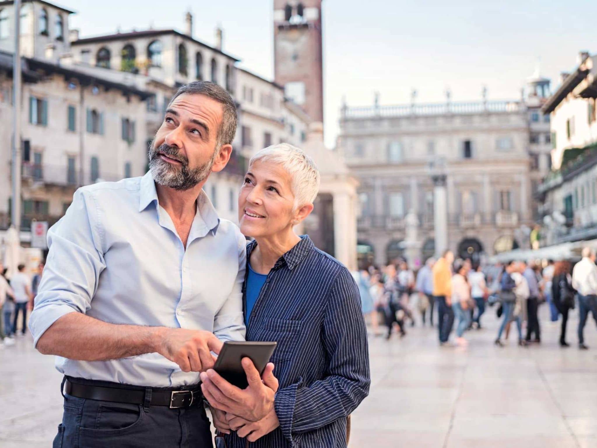 Bild: Älteres Paar auf Reisen schaut etwas im Handy nach.