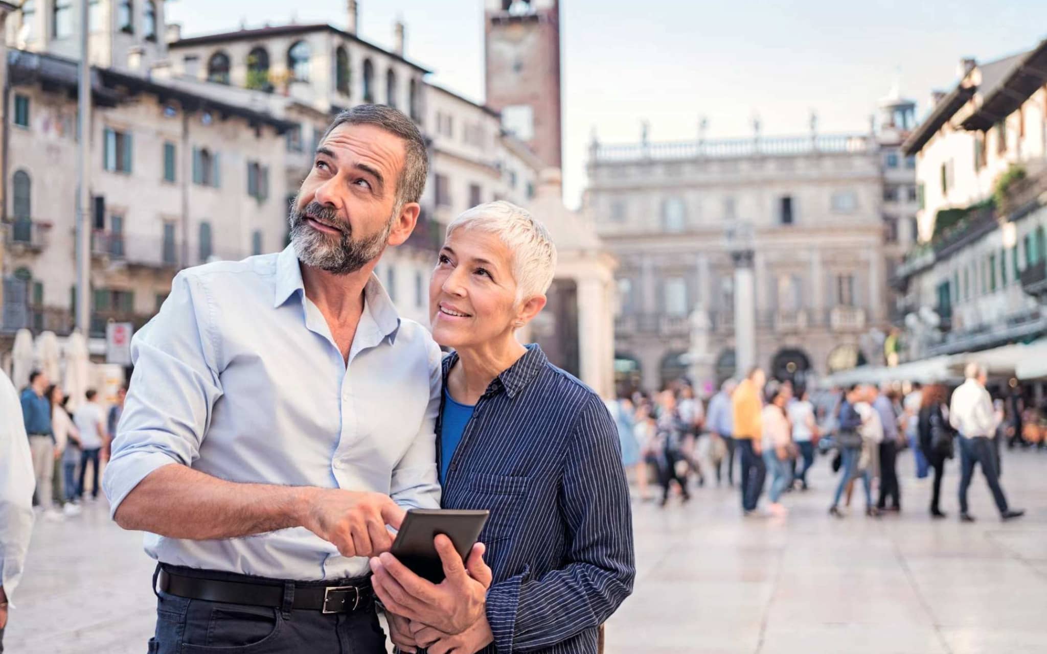 Bild: Älteres Paar auf Reisen schaut etwas im Handy nach.