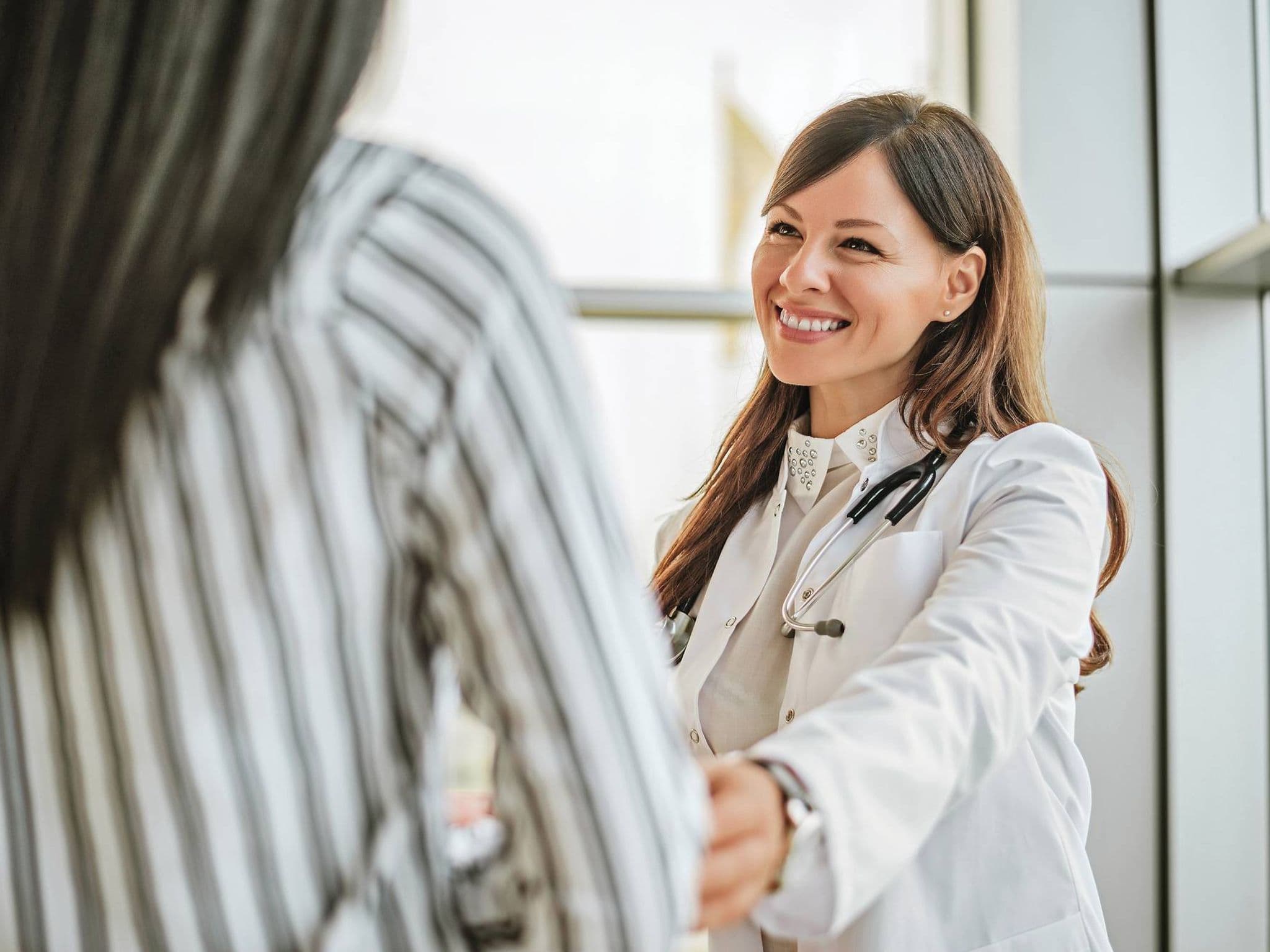 Bild: Ärztin begrüßt eine Patientin