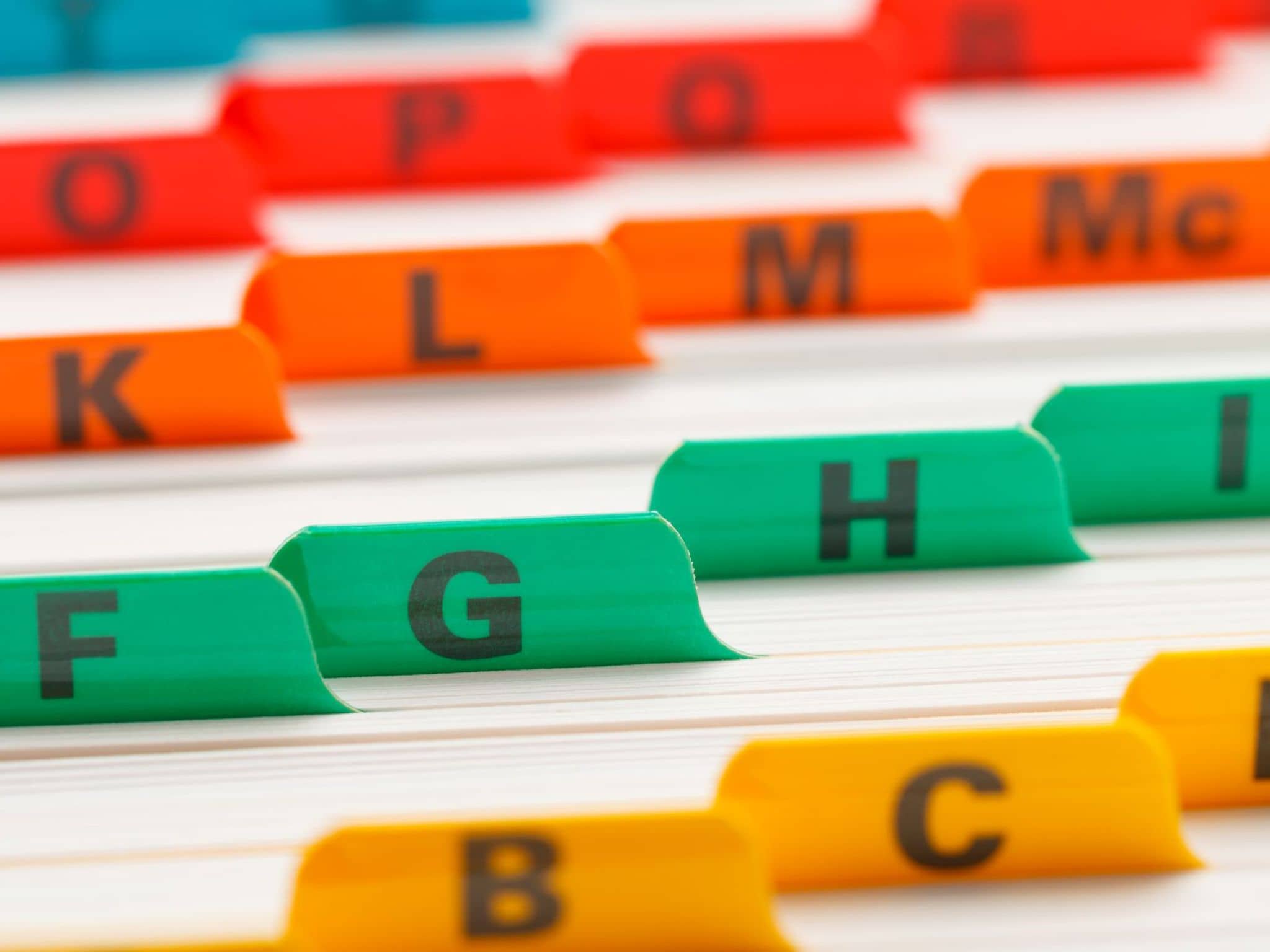 Bild: Nahaufnahme von Registerunterteilungen in Rot, Orange, Grün und Gelb.