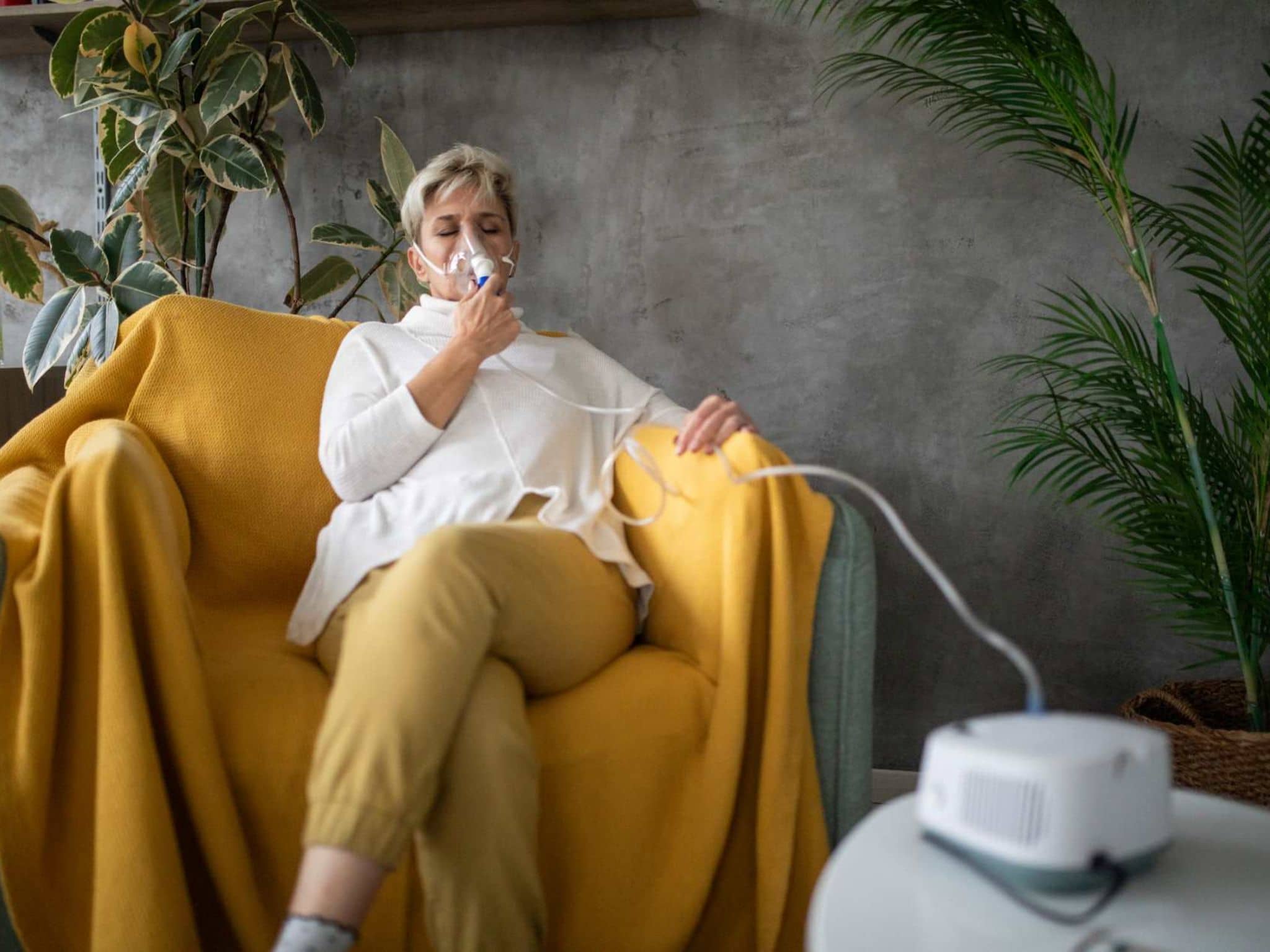 Bild: Frau inhaliert mit einem Inhalationsgerät