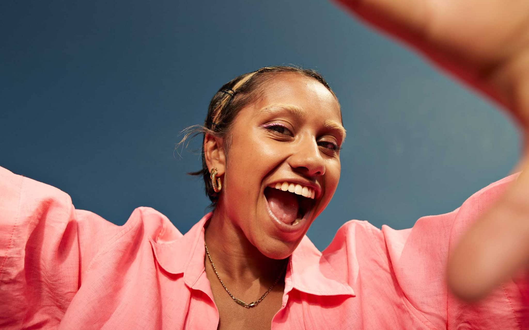 Krankenversicherung für Azubis: Junge Frau schreit vergnügt in die Kamera