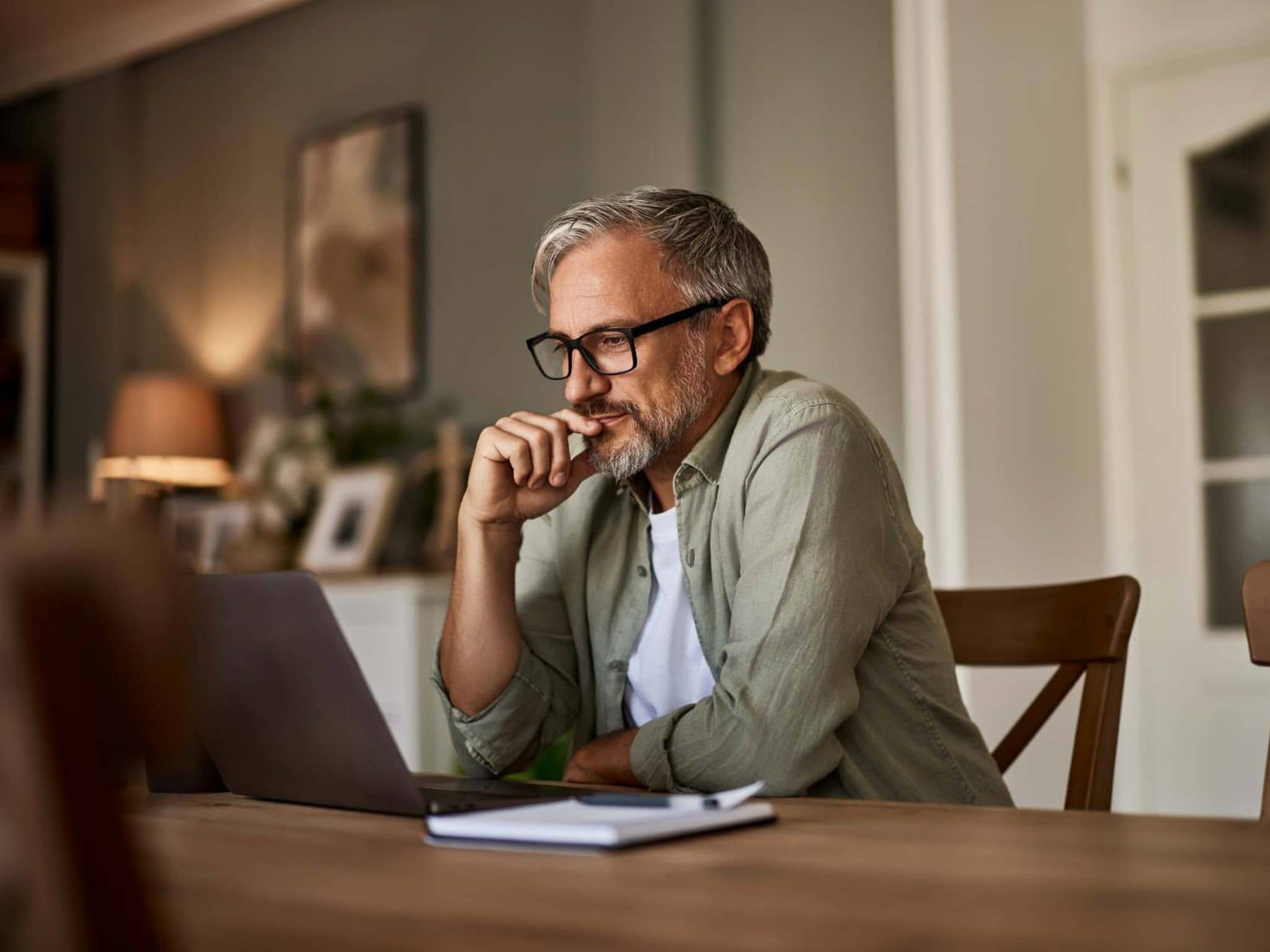 Bild: Mann mit Brille liest etwas am Laptop