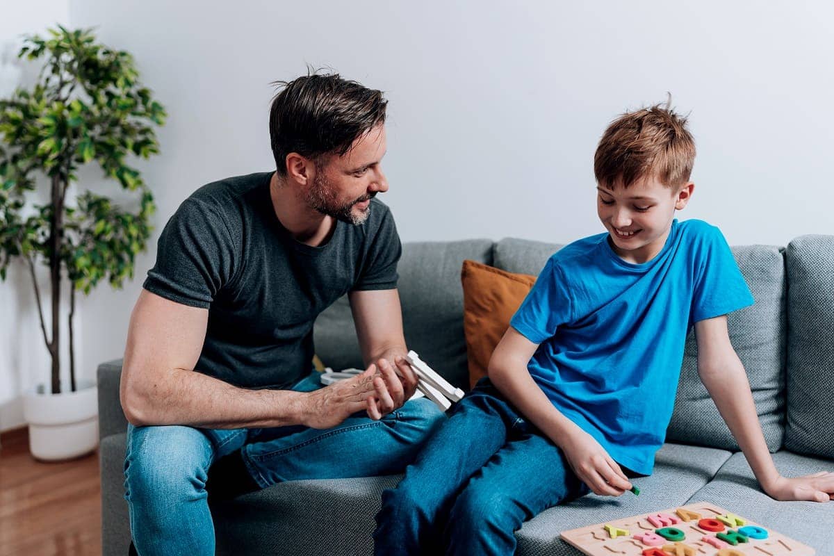 Vater und Sohn auf dem Sofa: Eltern können stotternden Kindern helfen.