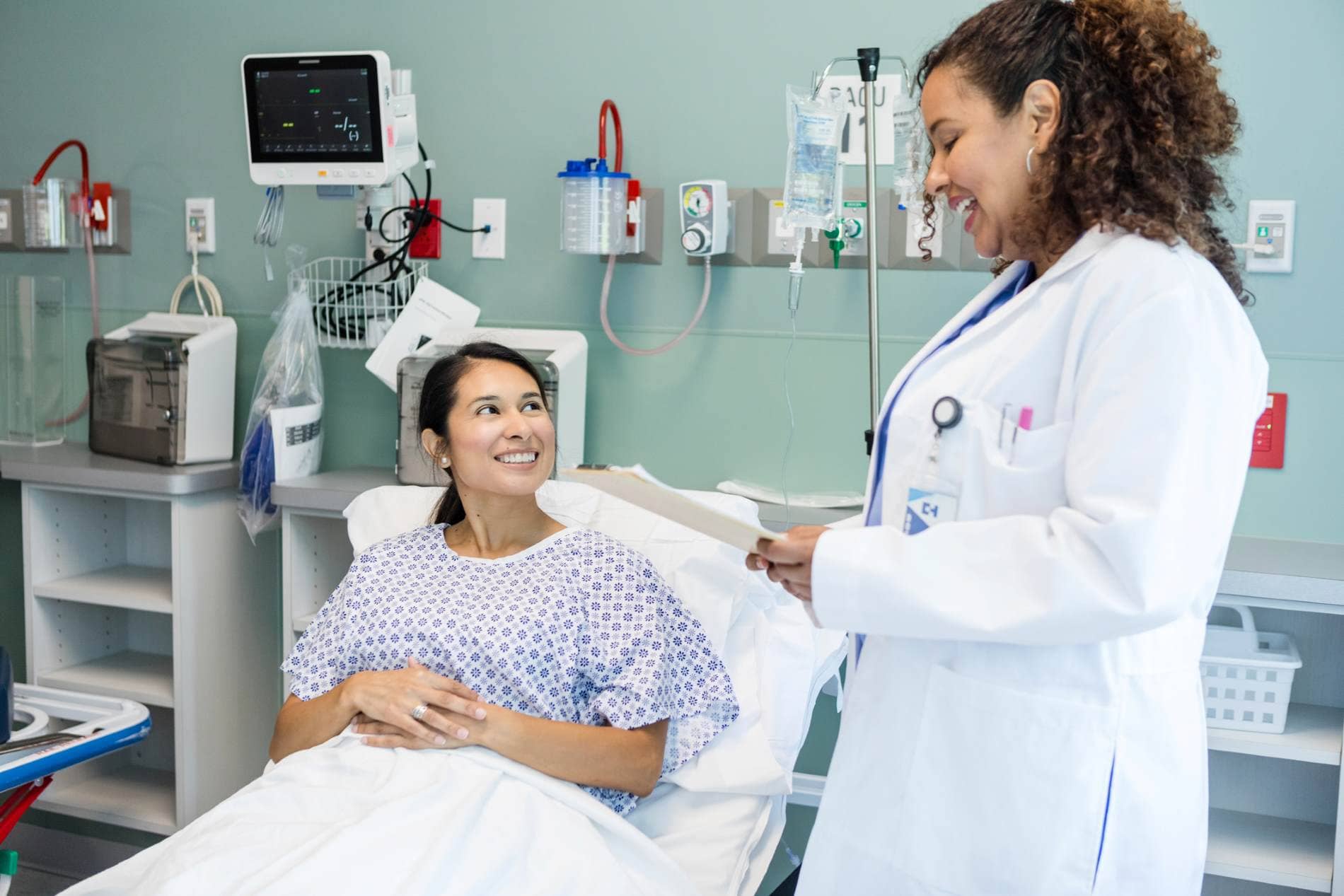 Bild: Ärztin spricht mit einer Patientin im Krankenbett