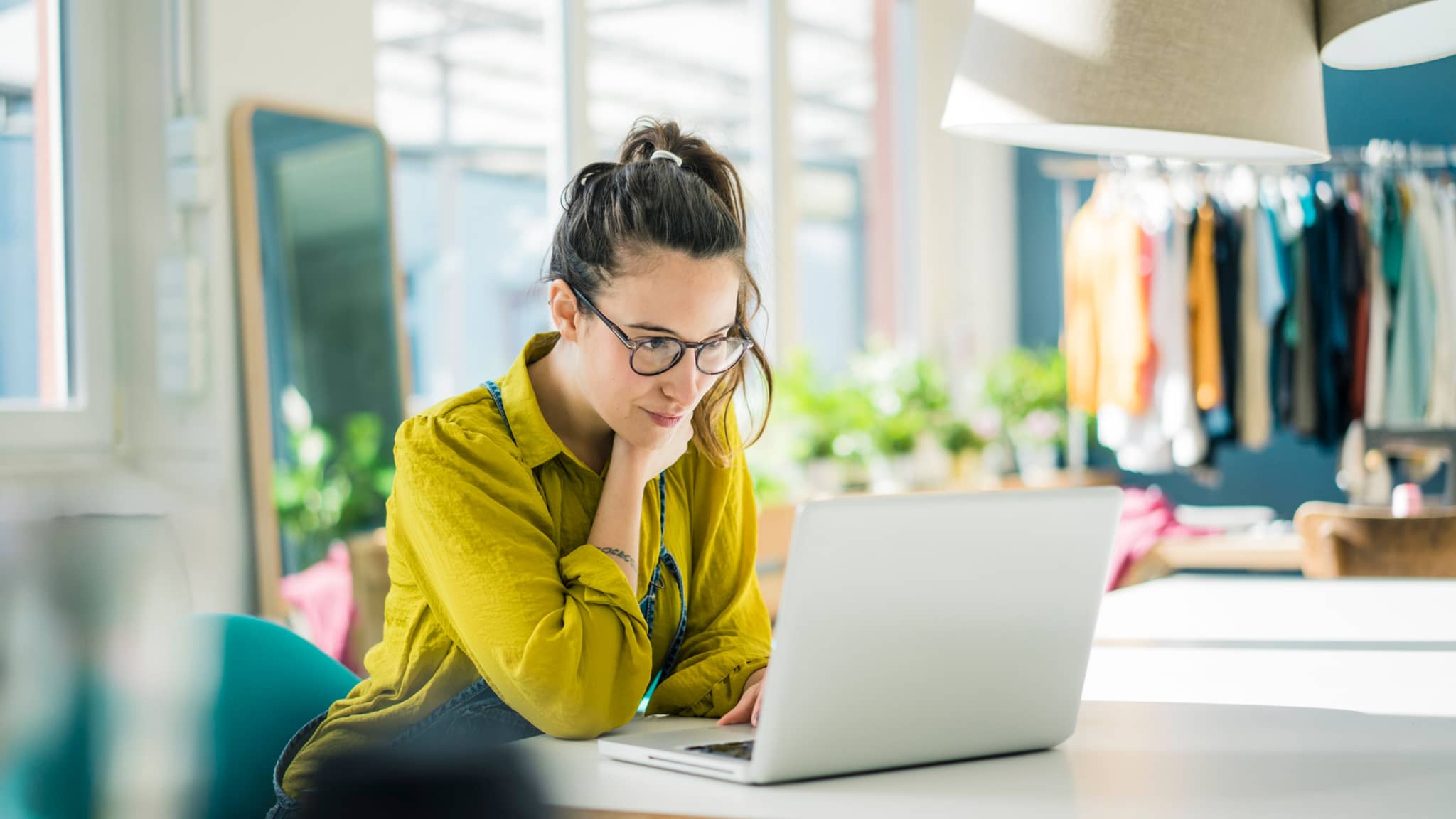 Symbolbild Homeoffice: Eine Frau sitzt vor einem Computer in ihrem Wohnzimmer