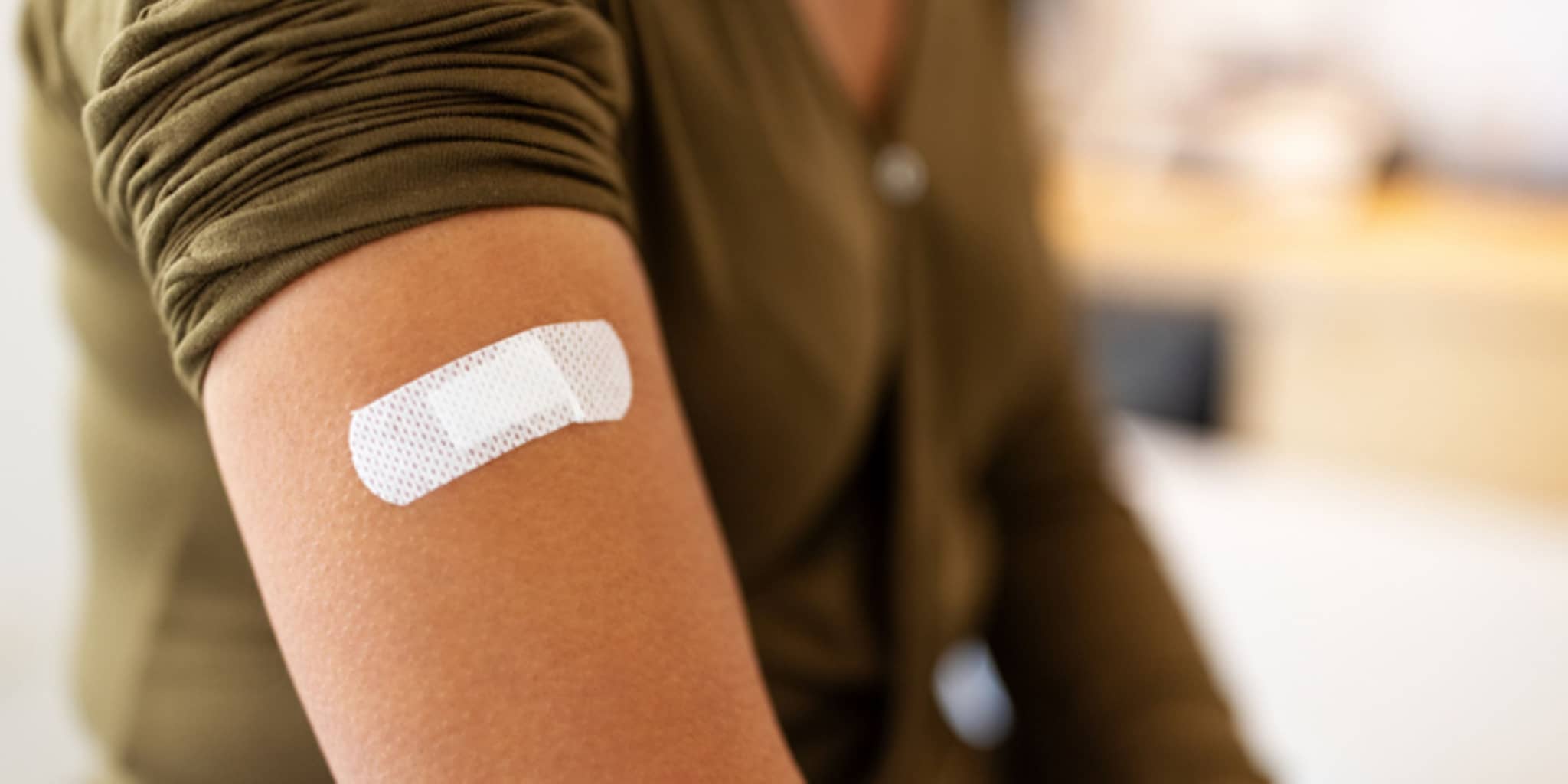Frau mit Pflaster am Oberarm