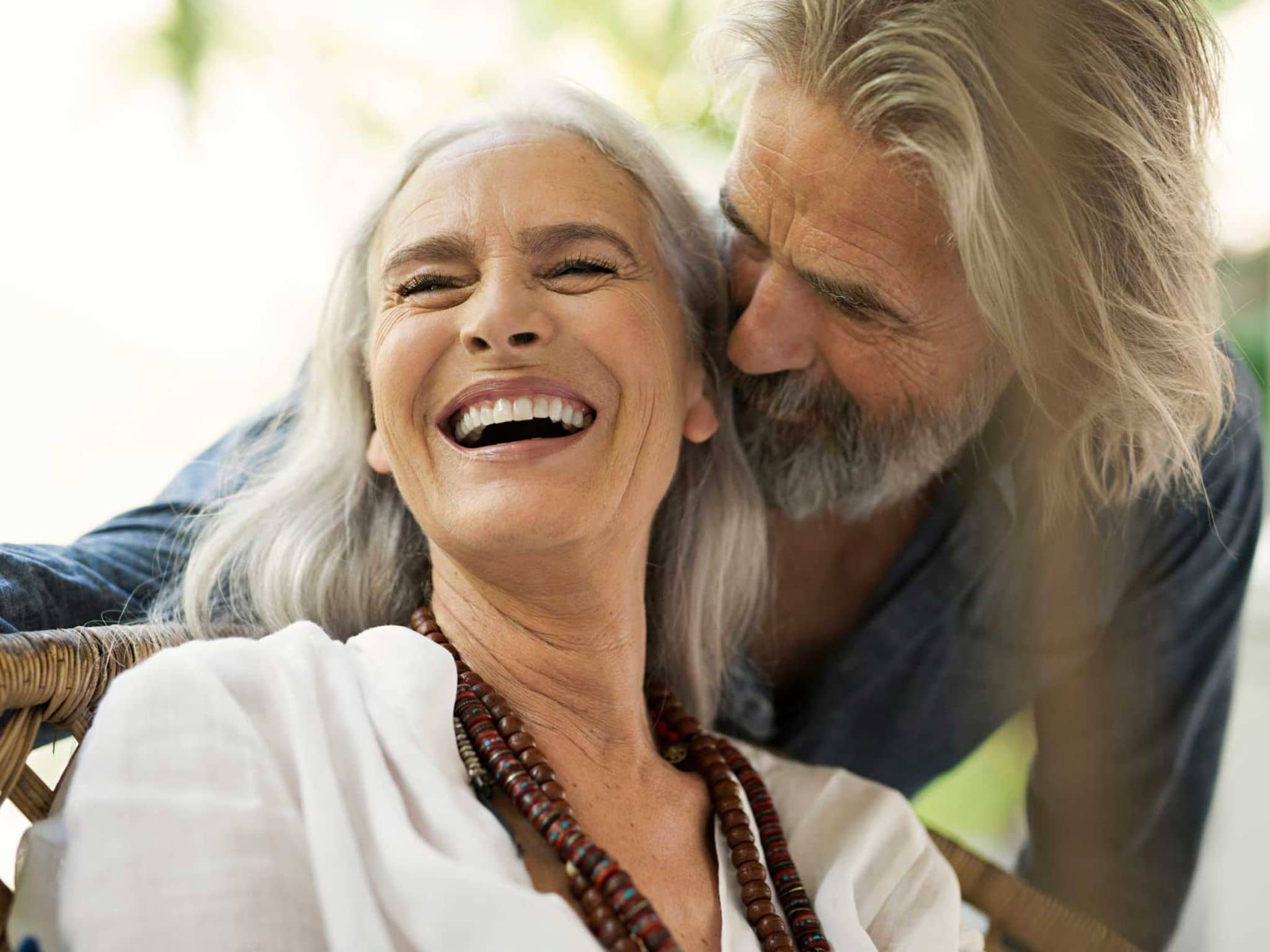 Glückliches Ehepaar lacht: Auch im Alter gut versichert