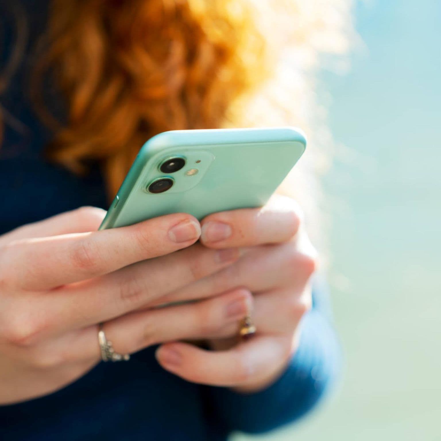 ePA App starten: Rothaare Frau startet ePA App auf ihrem Smartphone im Close-up