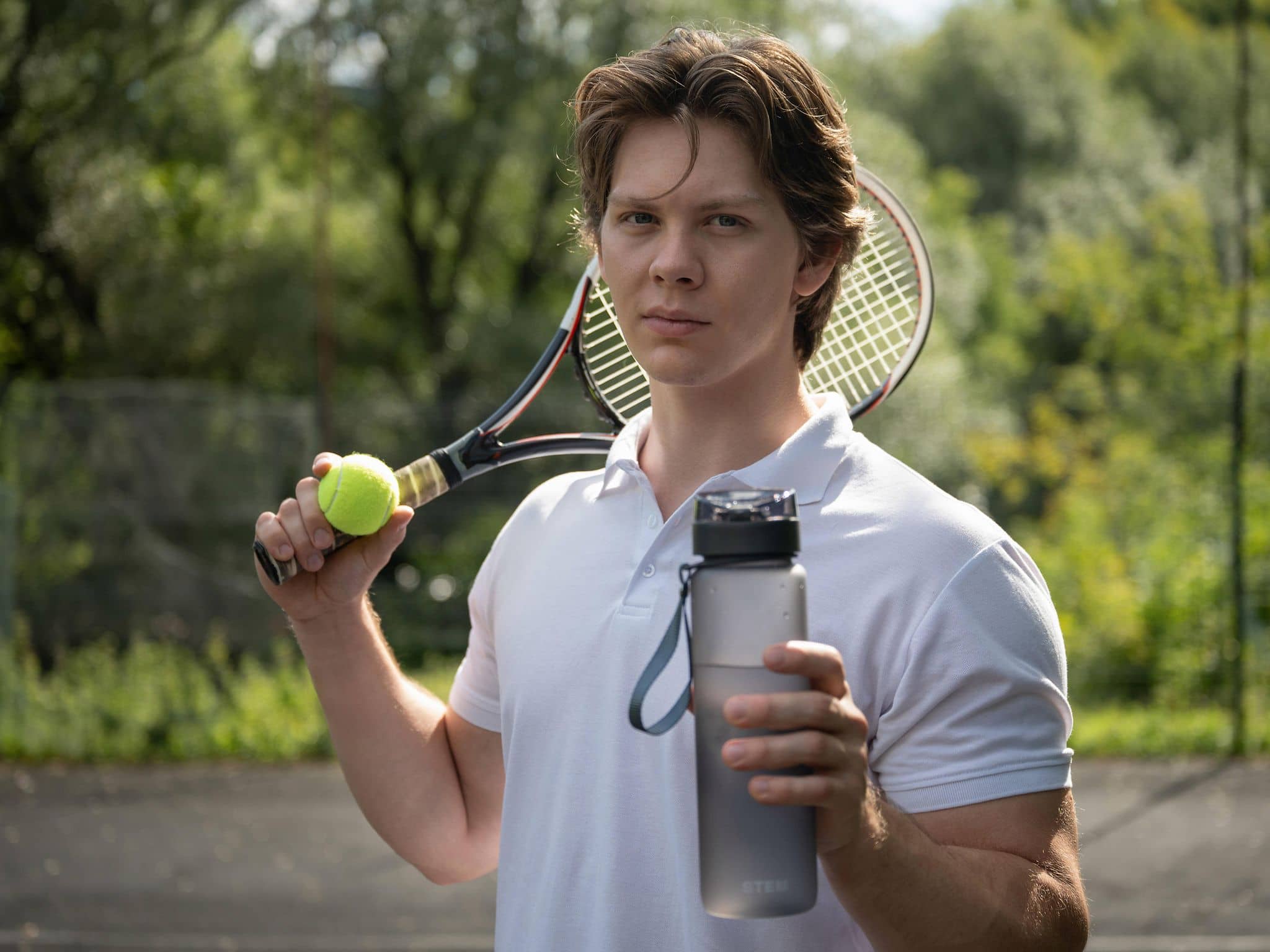 Spermafarbe: Junger Mann mit Wasserflasche, Tennisschläger und Tennisball.