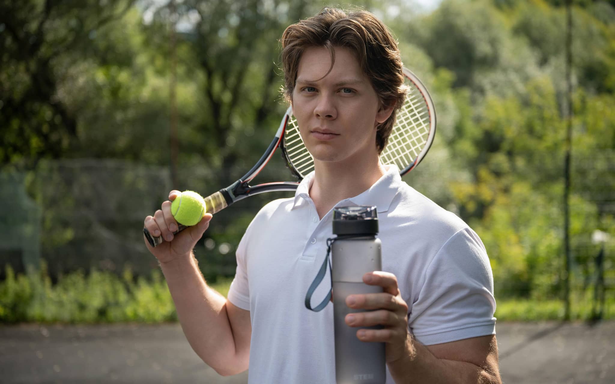Spermafarbe: Junger Mann mit Wasserflasche, Tennisschläger und Tennisball.
