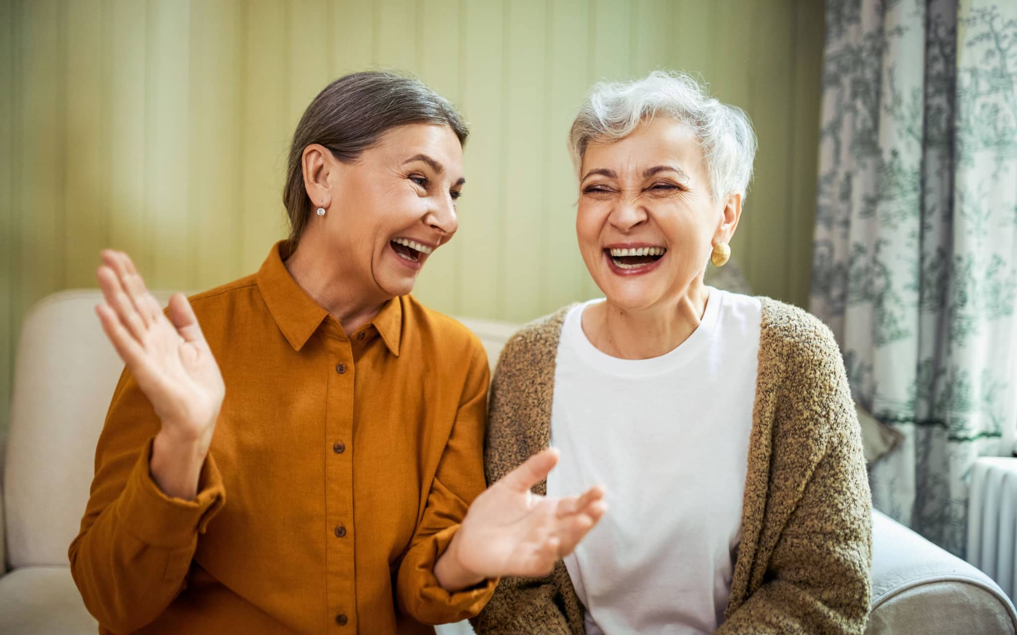 Zwei Frauen lachen gemeinsam und erkennen, dass Lachen gesund ist