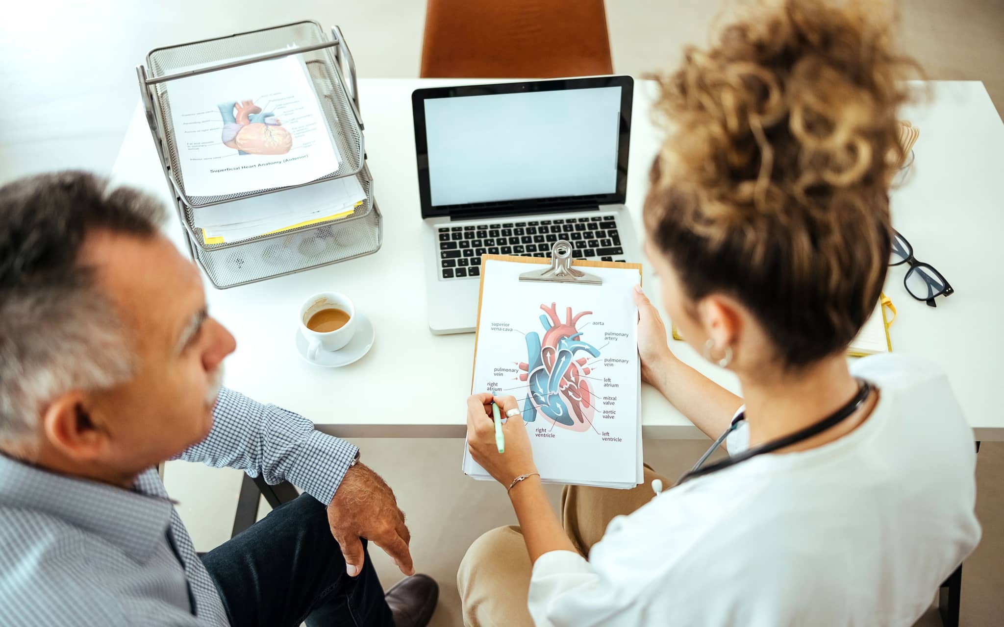 Zweitmeinung-Cardio: Ärztin berät männlichen Patienten zum Thema Herz-Operation