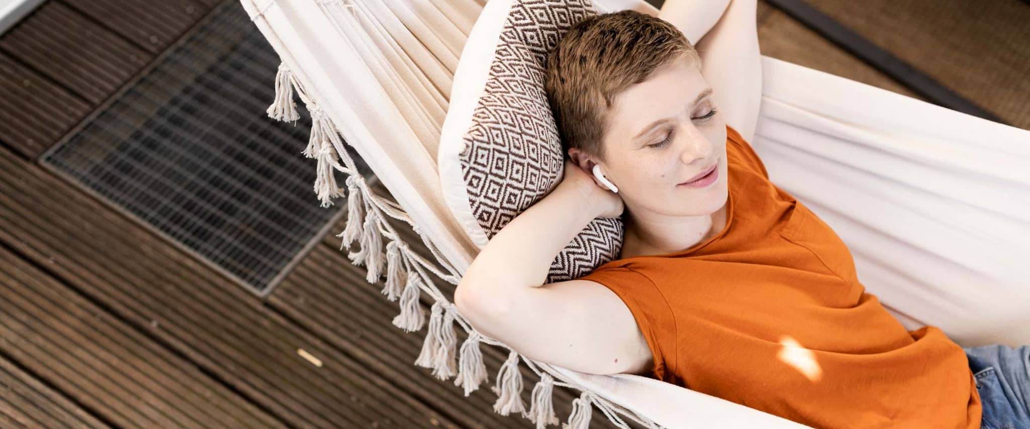 Eine junge Frau liegt mit geschlossenen Augen in einer Hängematte.