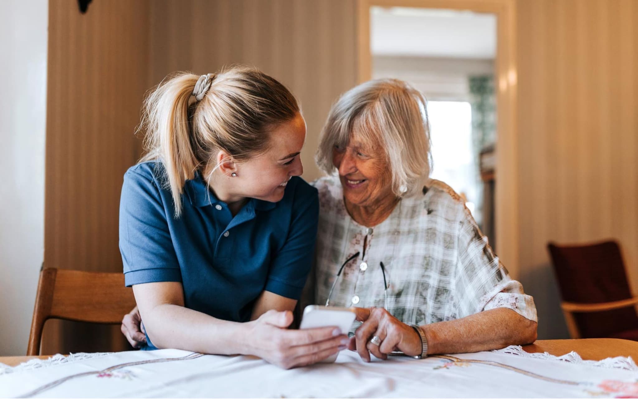 ReKo: Case Managerin hilft einer Seniorin bei der Bedienung eines Smartphones.