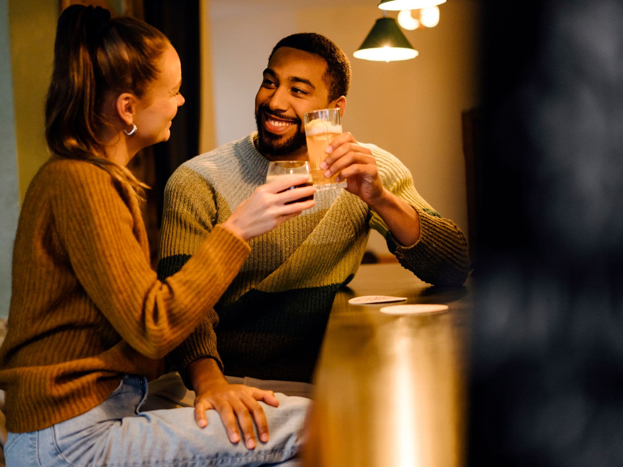 Körpersprache des Flirtens: Ein Mann flirtet mit einer jungen Frau und legt seine Hand auf ihren Oberschenkel