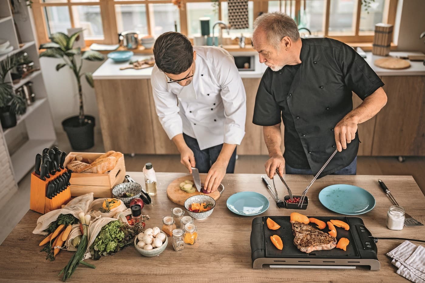 Zwei Männer bereiten Essen in der Küche vor.