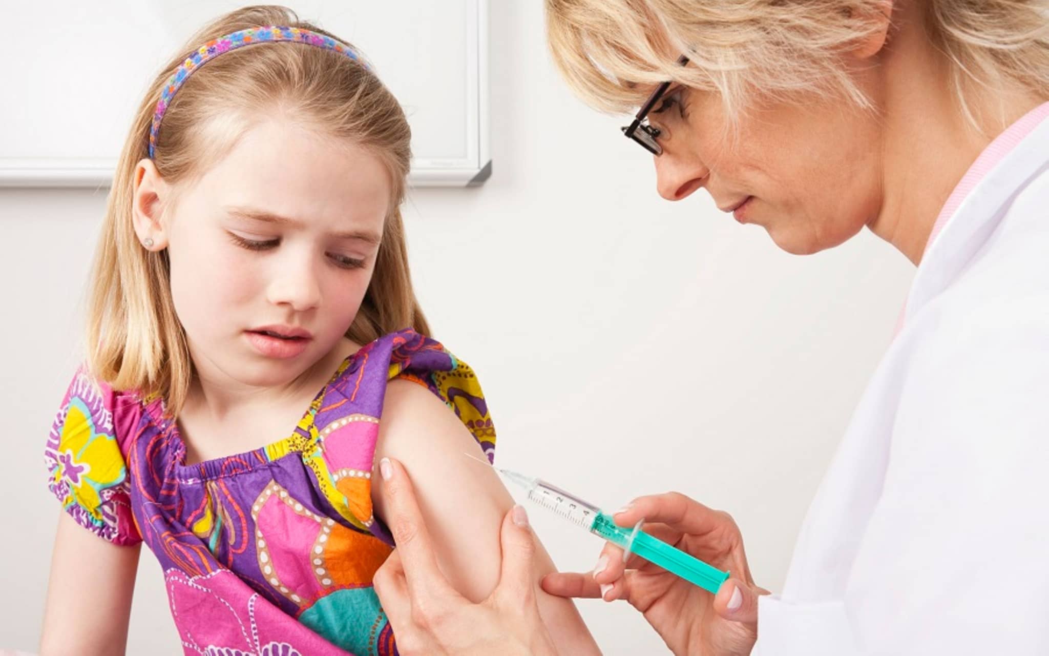 Schutz vor Erkrankungen durch eine HPV-Impfung: Ärztin impft Mädchen.