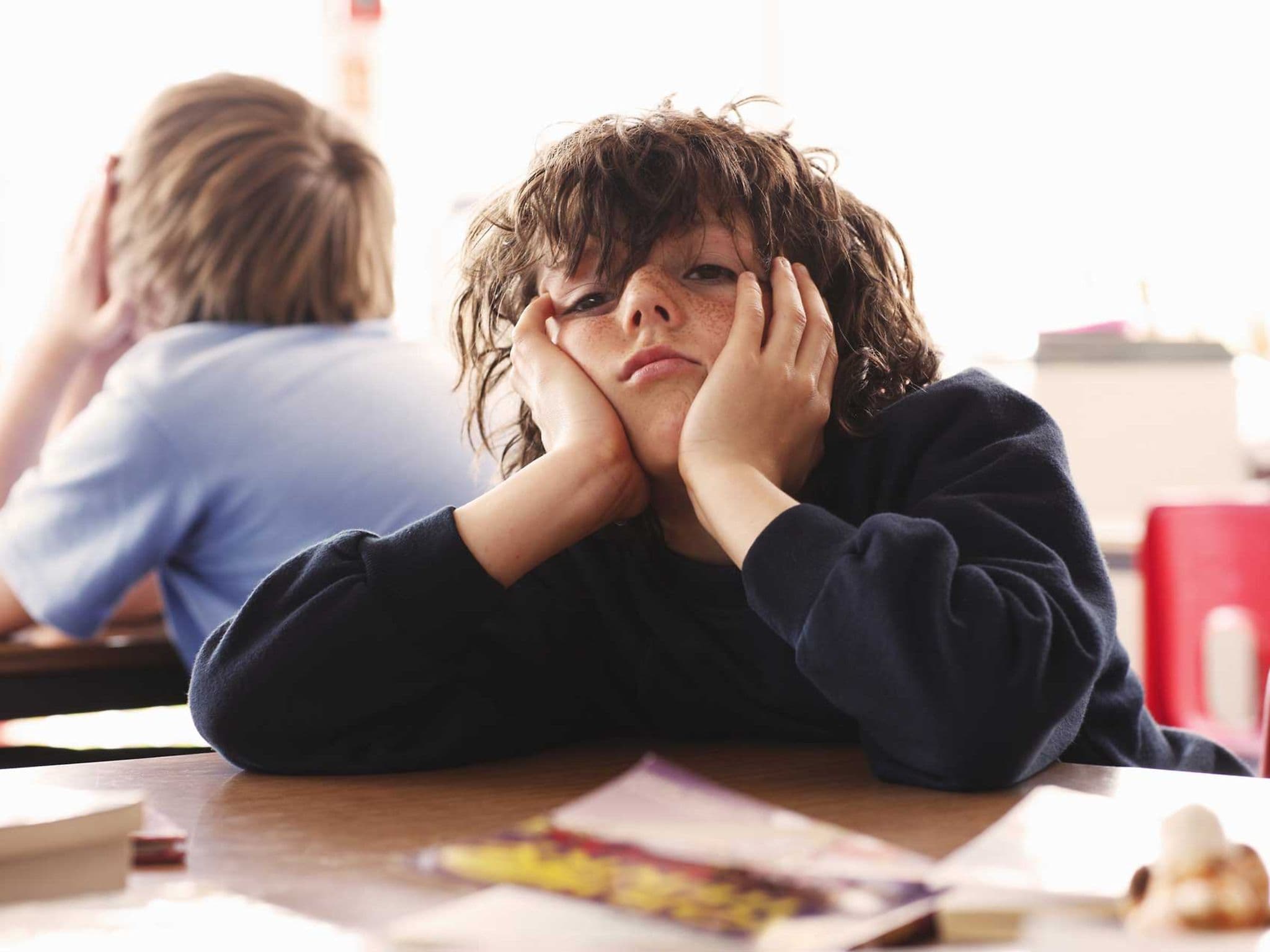 Symbolbild ADHS bei Kindern: Junge langweilt sich in der Schule