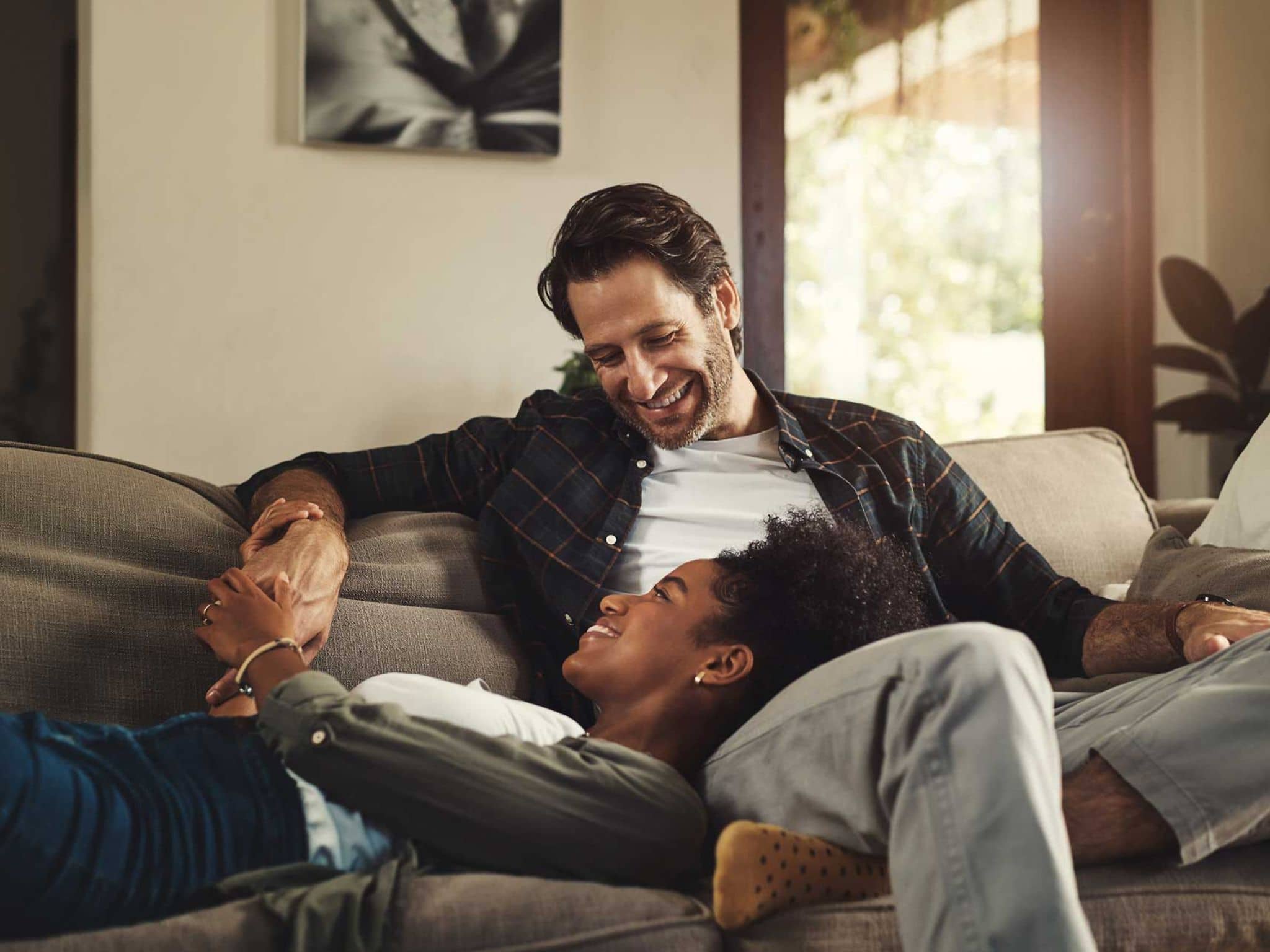 Symbolbild Spermienqualität: Paar sitzt gemeinsam auf Couch