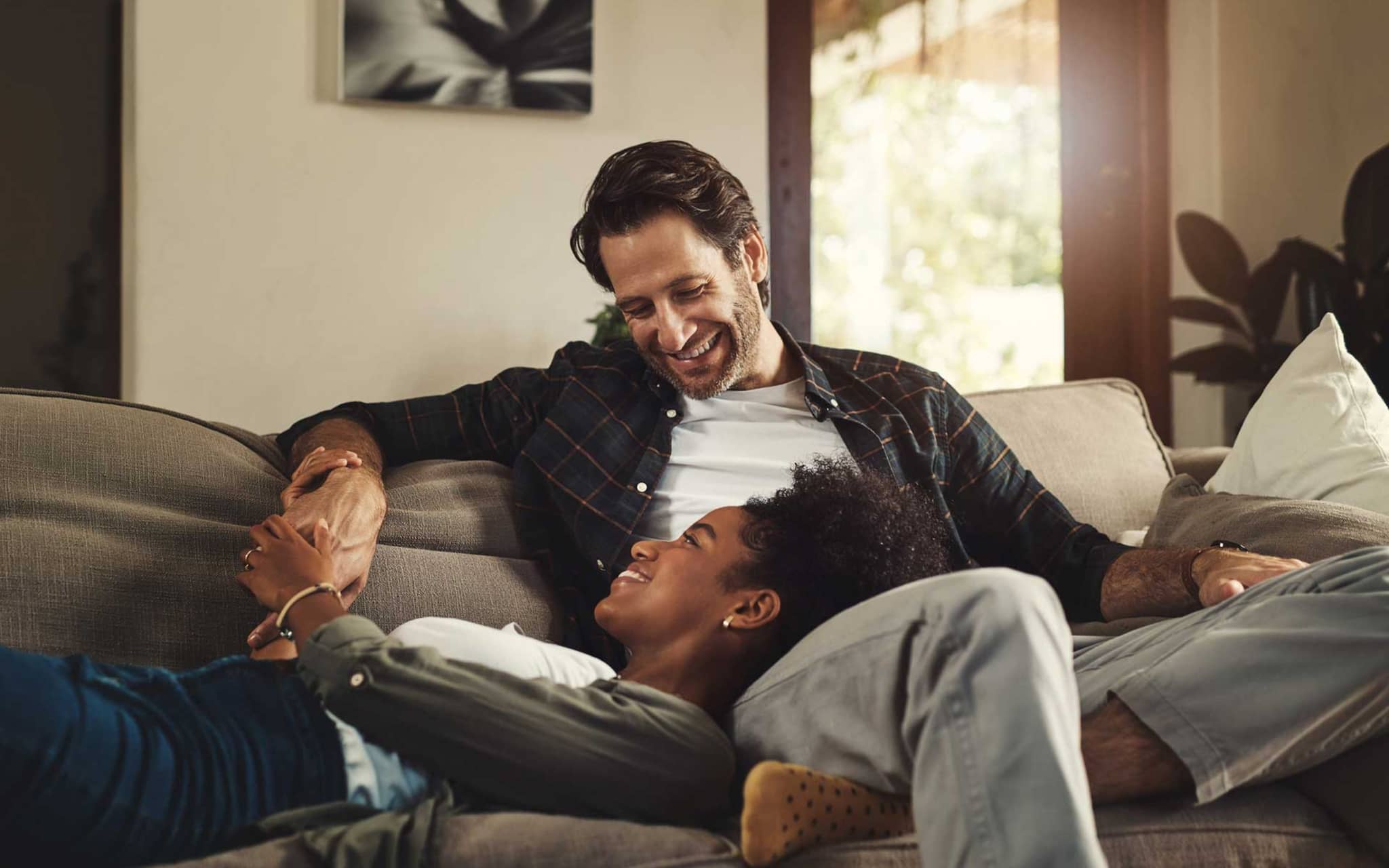 Symbolbild Spermienqualität: Paar sitzt gemeinsam auf Couch