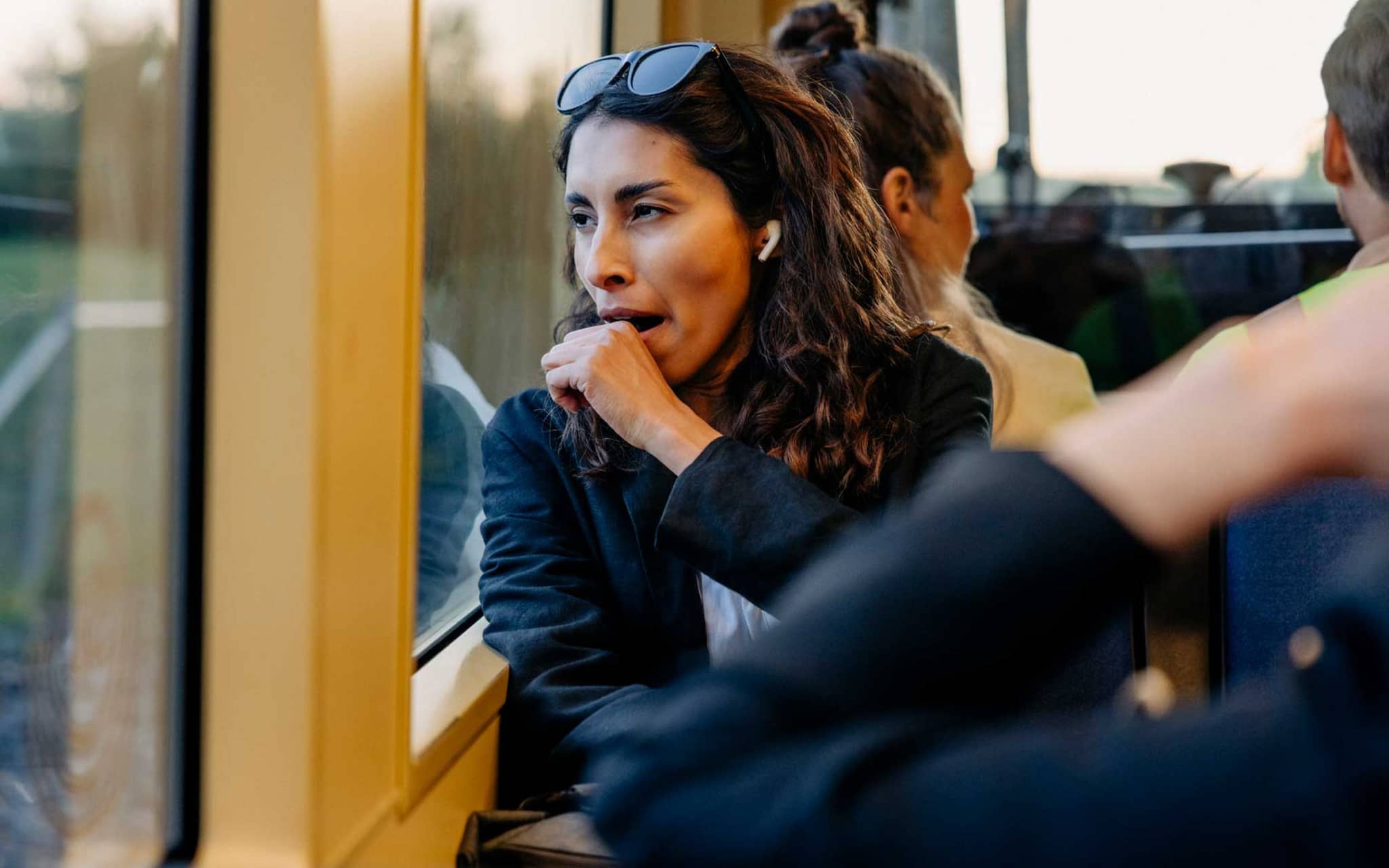 Symbolbild ständig müde: Müde Frau gähnt auf dem Weg zur Arbeit