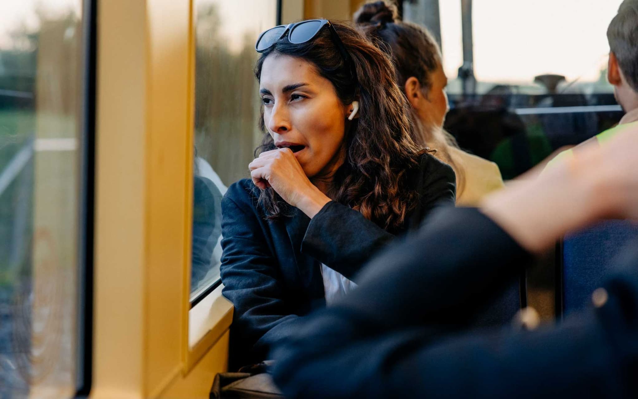 Symbolbild ständig müde: Müde Frau gähnt auf dem Weg zur Arbeit