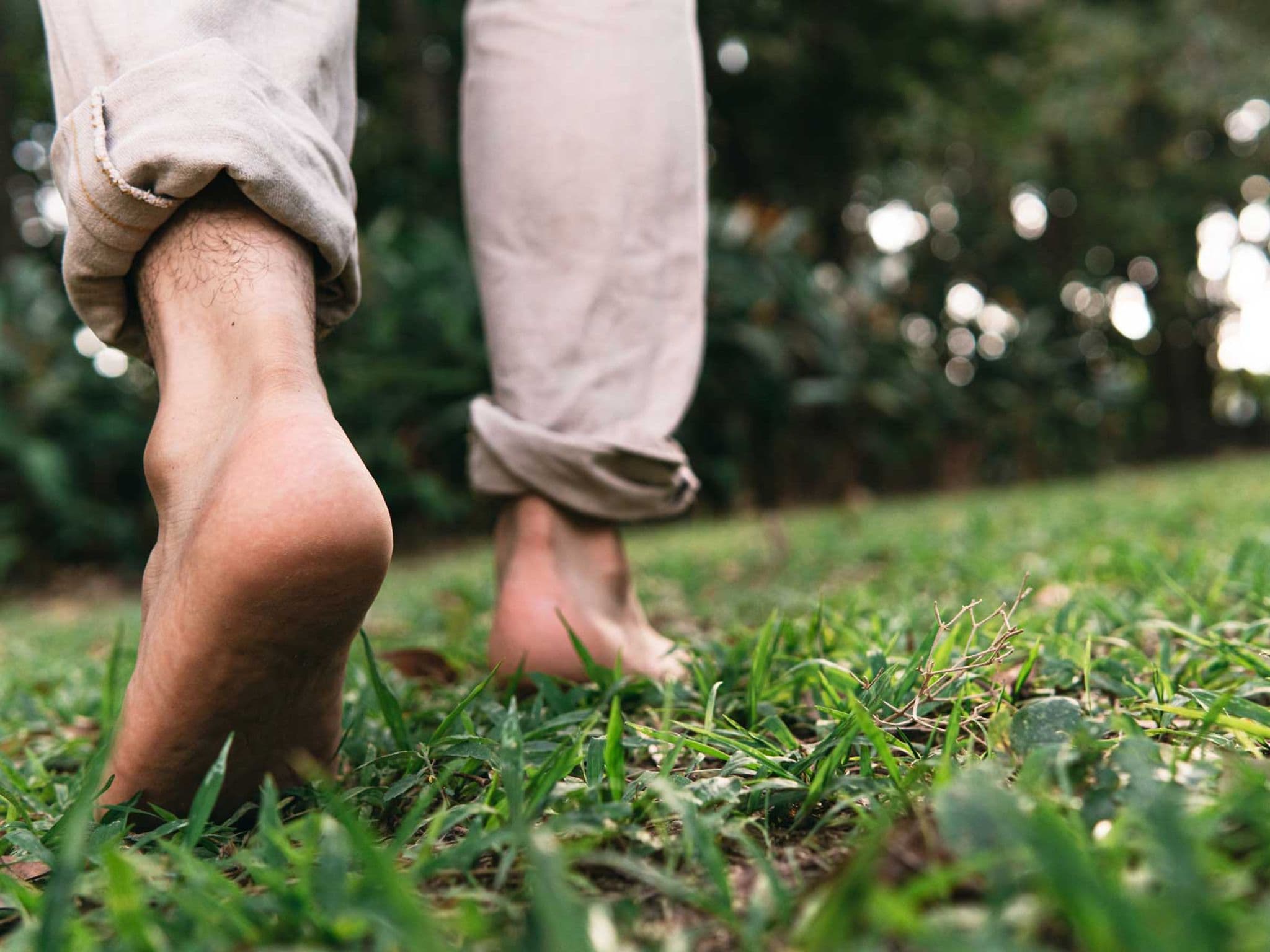Symbolbild Diabetischer Fuß: Mann läuft barfuß im Gras